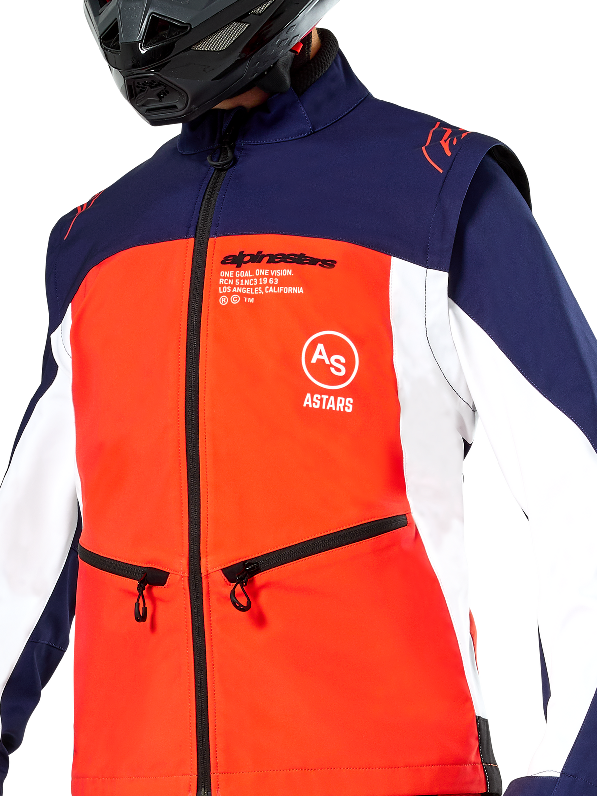 Alpinestars Lite-Dura Softshell-Jacke in Navy, Hot Orange und Weiß, Nahaufnahme des Oberkörpers mit einer leuchtend orangefarbenen Vorderseite, weißen Seitenbahnen und dunkelblauen Schultern, Reißverschlusstaschen und markantem Alpinestars-Branding, getragen von einem Fahrer mit schwarzem Offroad-Helm.