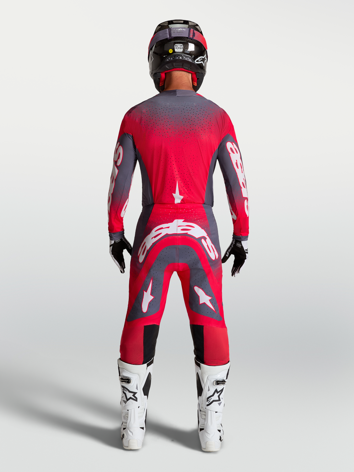 Alpinestars Supertech Hiten AFD Gear Set und Hose, Motocross-Rennbekleidung in Rot Fluo und Grau, Rückansicht am Model.