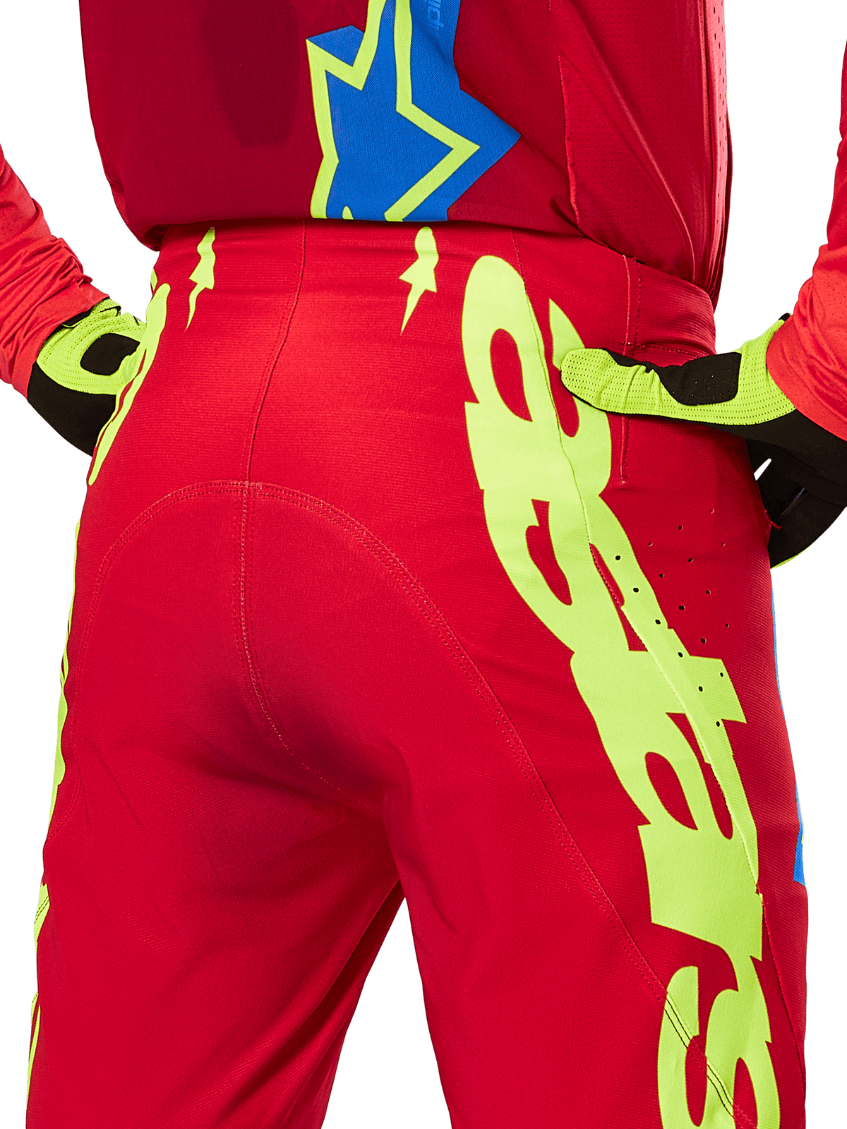 Alpinestars 2025 Supertech Maker Hose, Motocross-Hose, Hellrot und Gelb Fluo, rückseitige Nahaufnahme mit markanten neongelben Grafiken, getragen mit passendem rotem Trikot und gelb-schwarzen Handschuhen
