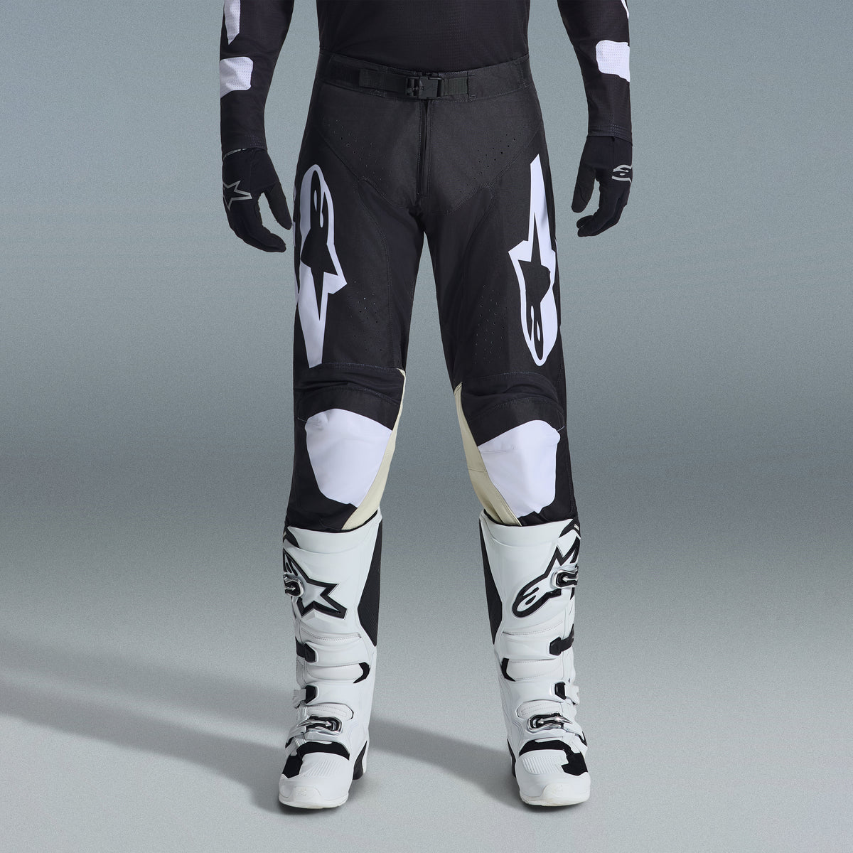 Alpinestars 2026 Racer Air Riway Bekleidungsset, schwarz-weiße Motocross-Hose mit hellbraunen Knie-Innenpaneelen, kombiniert mit weißen Rennstiefeln und schwarzen Handschuhen, leichte belüftete Offroad-Rennausrüstung