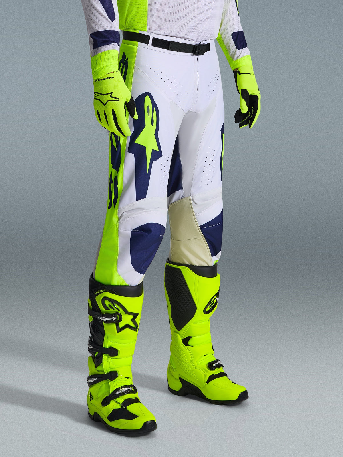 Alpinestars 2026 Racer Air Riway Hose, Motocross-Hose, Hellgrau, Gelb Fluo und Blau, getragen mit passenden Handschuhen und Stiefeln in Gelb Fluo, mit großem blauem Branding am Oberschenkel und perforierten Belüftungspanelen, strapazierfähige Motocross-Ausrüstung