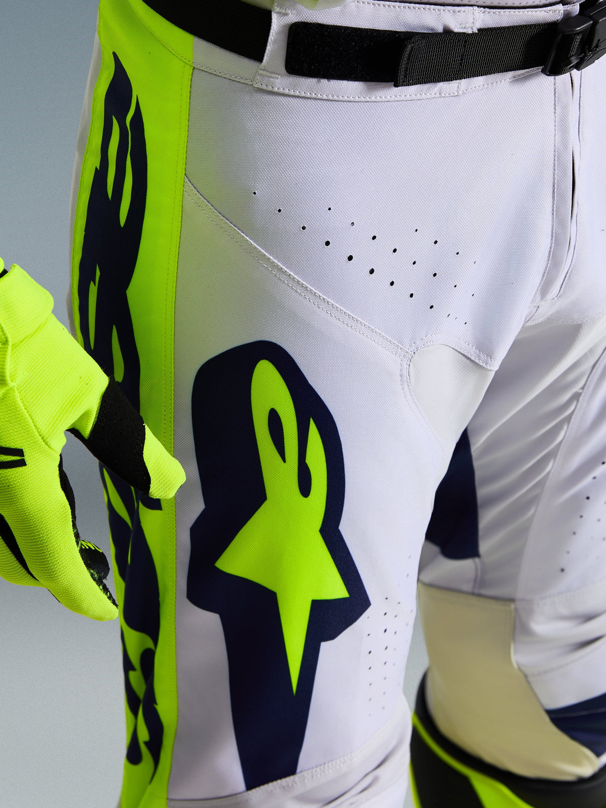 Alpinestars 2026 Racer Air Riway Hose, Motocross-Hose, Hellgrau mit Gelb Fluo und blauen Akzenten, Nahaufnahme des Oberschenkels mit großem Alpinestars-Logo und Belüftungsperforationen, strapazierfähige Rennpassform-Konstruktion.