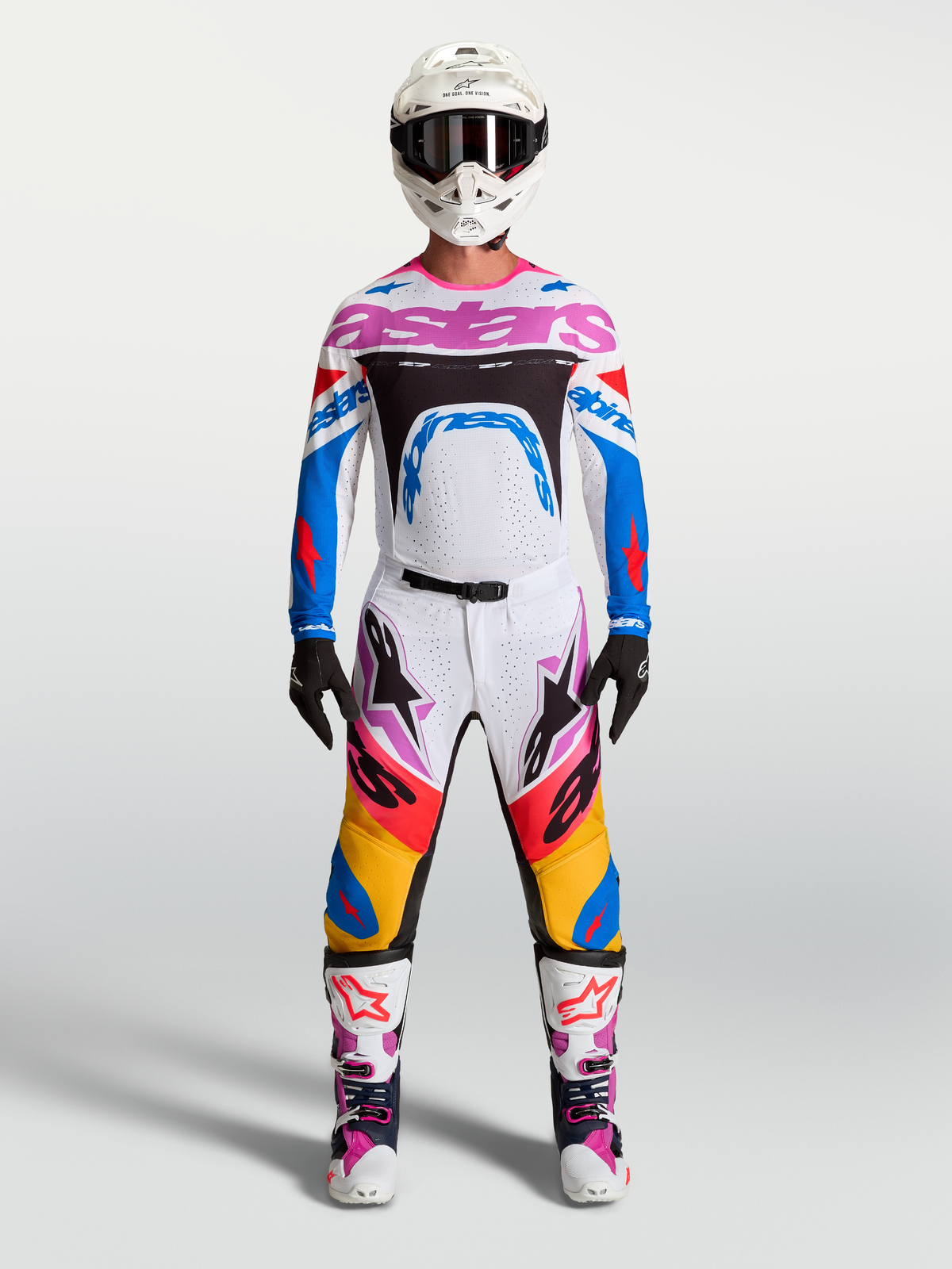 Alpinestars Supertech Dyna Pants and gear set, men's white and blue motocross racing outfit with pink accents.