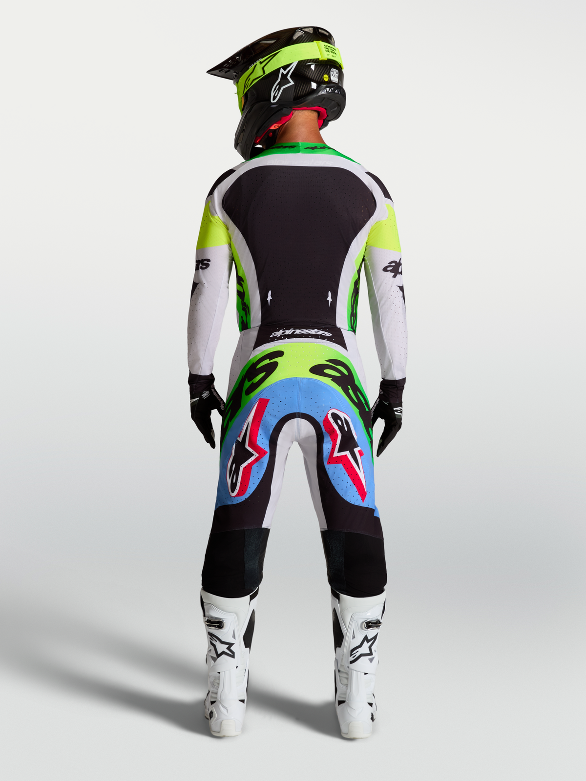 Alpinestars Supertech Dyna Hose, Motocross-Hose in Helllila und Grün, Rückansicht eines Fahrers im Rennkit.