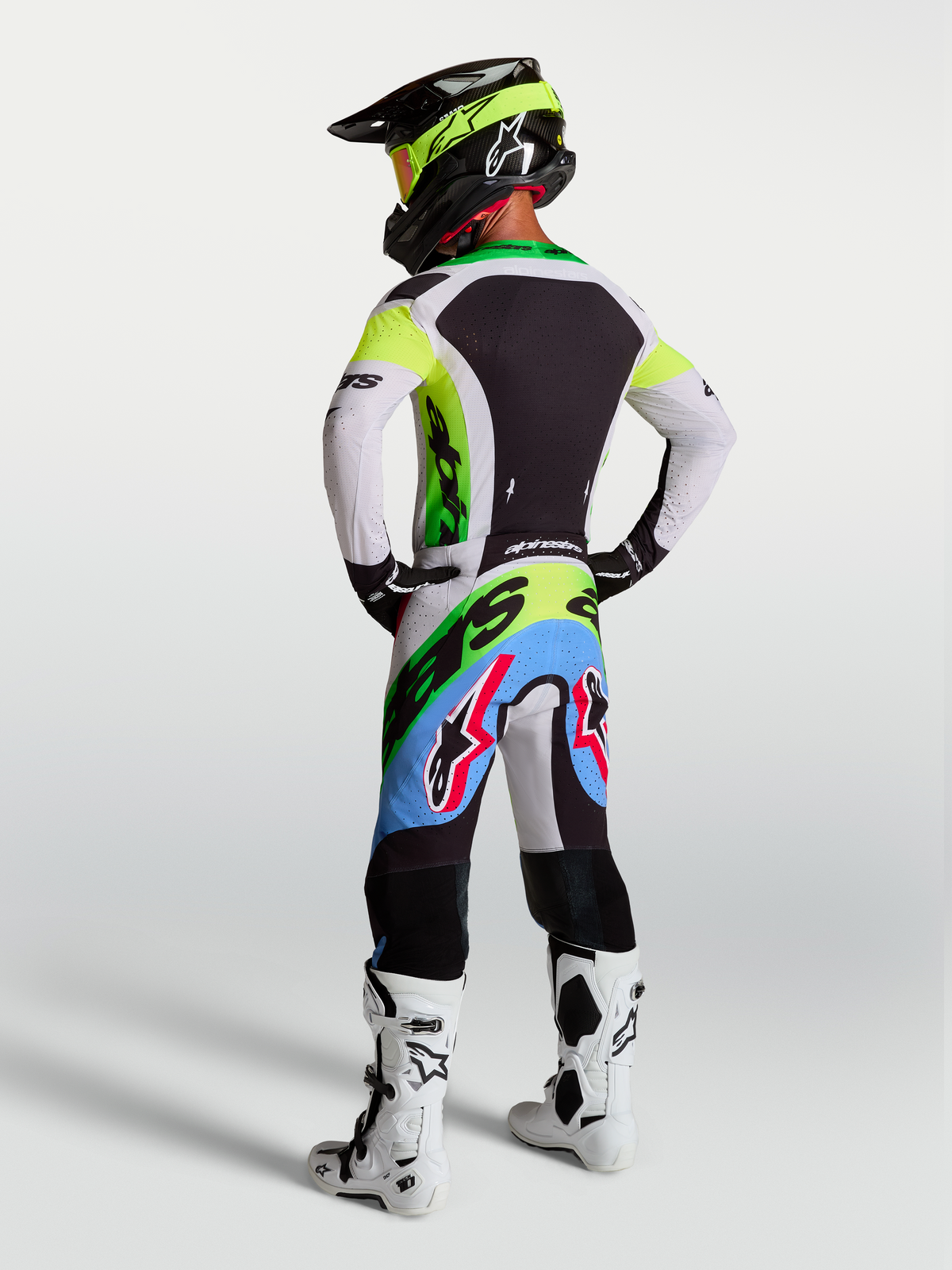 Alpinestars Supertech Dyna Motocross-Ausrüstung für Herren, Supertech Dyna Hose und Trikot in Grün Fluo, Schwarz und Helllila, Rückansicht eines Fahrers.
