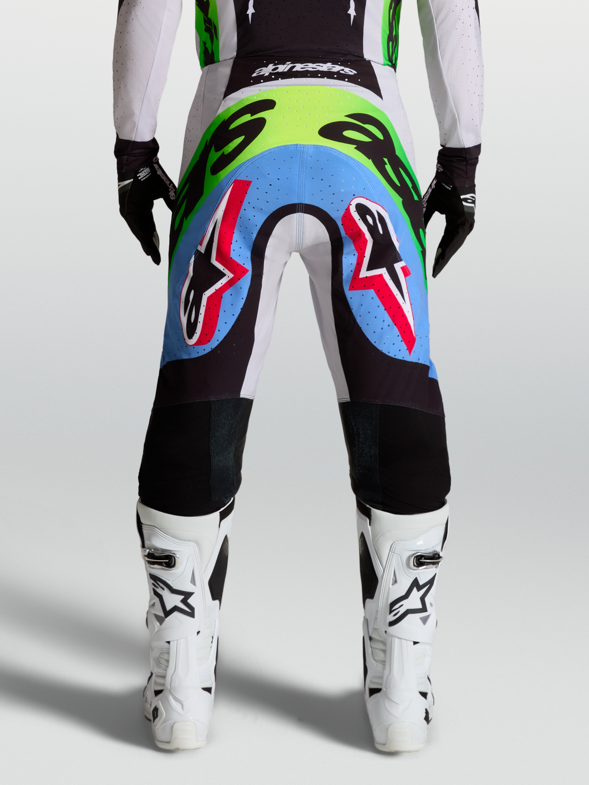Alpinestars Supertech Dyna Herren-Motocross-Hose, Rückansicht in Helllila und Neongrün mit perforierten Stretcheinsätzen.