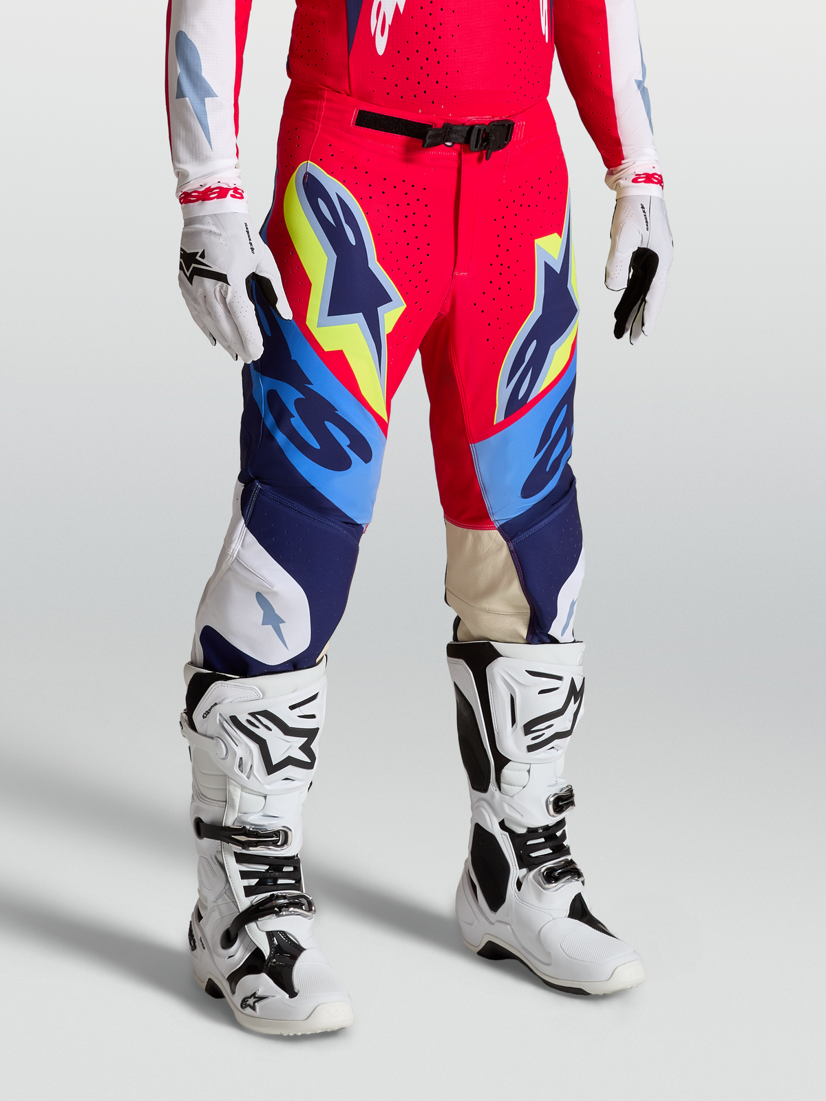 Alpinestars Supertech Dyna Hose, Motocross-Hose in Rot, Weiß und Navy-Blau, athletische Rennpassform mit Stretch-Ripstop-Gewebe, getragen mit Tech 10 Stiefeln und Handschuhen, professionelle Offroad-Ausrüstung.