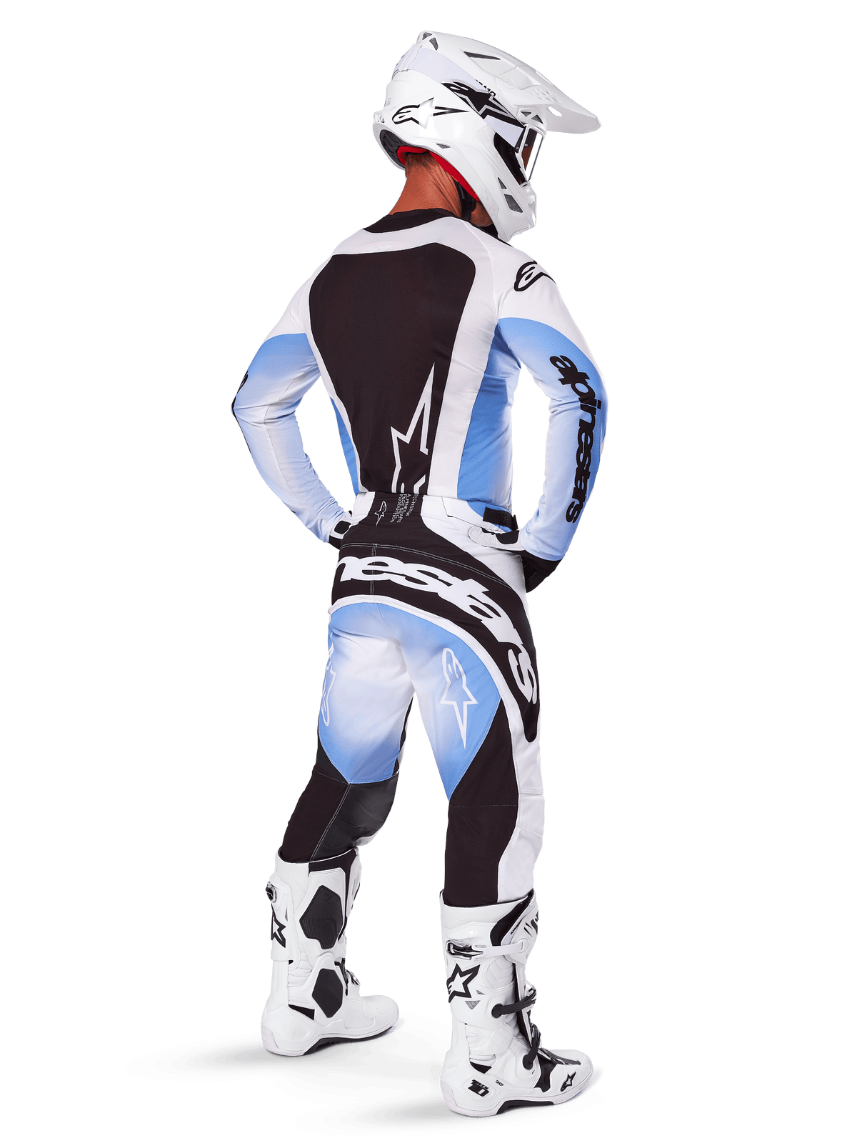 Motocross-Fahrer von hinten, Alpinestars 2025 Techstar Melt Hose und Trikot, schwarz-blau-weißes Farbverlaufsdesign, weißer Helm, weiß-schwarze Stiefel, komplette Offroad-Rennausrüstung.