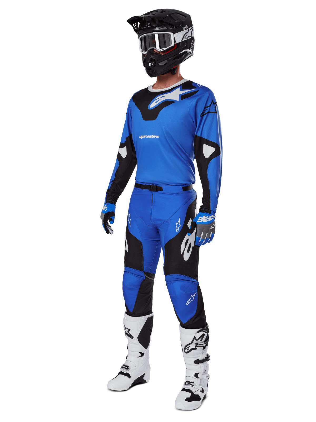 Motocross-Fahrer in kompletter Rennausrüstung, mit Alpinestars Racer Veil Hose 2025 in Blau und Schwarz, passendem blauen Trikot mit weißen Akzenten, schwarzem Helm mit weißer Schutzbrille, weiß-schwarzen Stiefeln und blauen Handschuhen, abgestimmtes Outfit für Offroad-Rennen