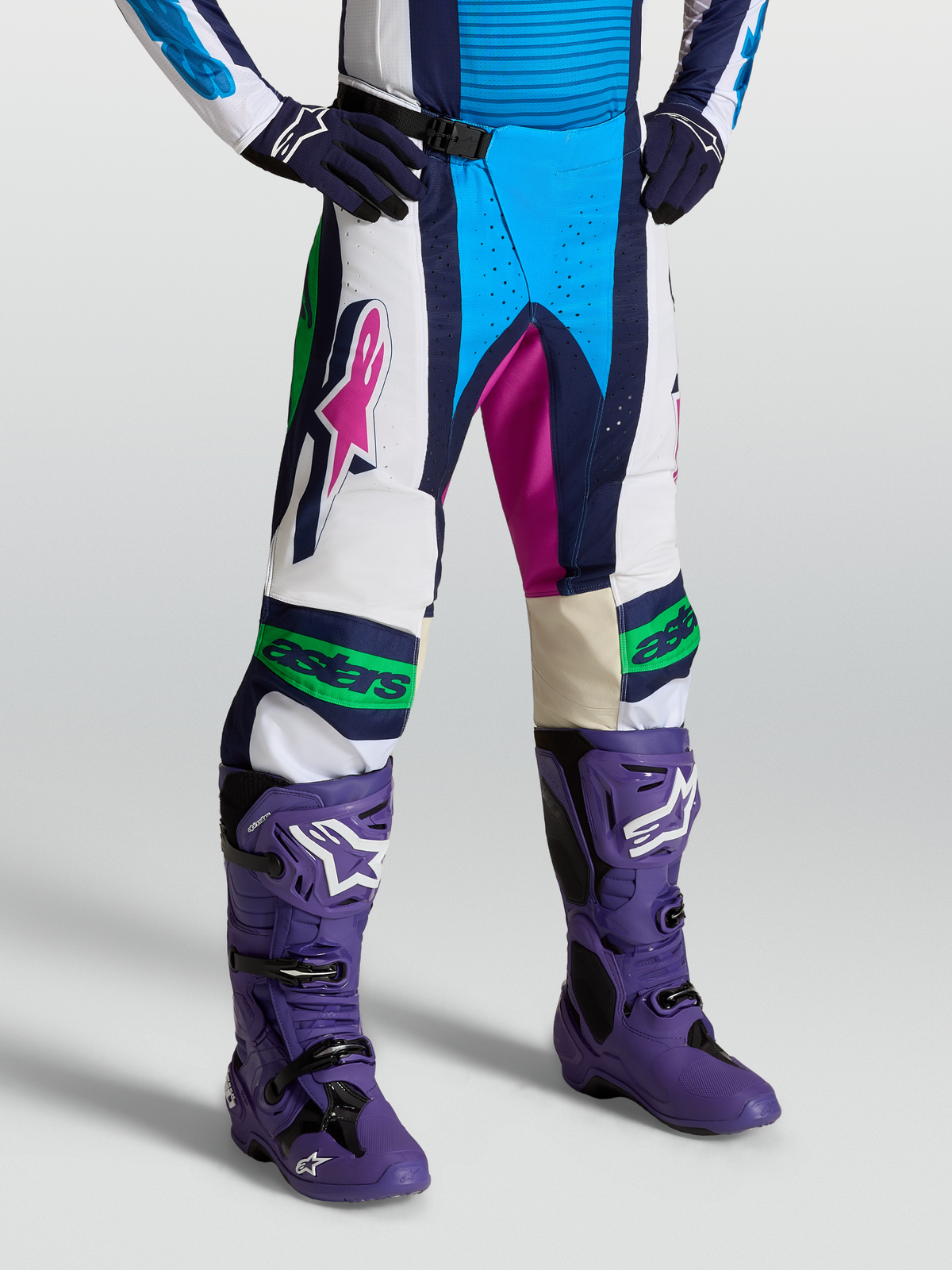Alpinestars Techstar Maven Hose für Motocross, Blau und Weiß, getragen mit lila Stiefeln, 600D-Polygewebe und Magnetschnalle.