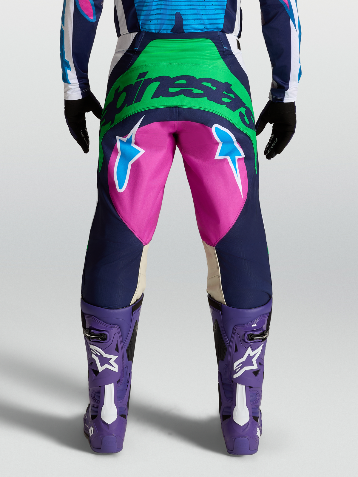 Alpinestars Techstar Maven Hose, Motocross-Hose in Blau und Pink, Rückansicht am Model mit Alpinestars-Logo und Stern-Grafiken.