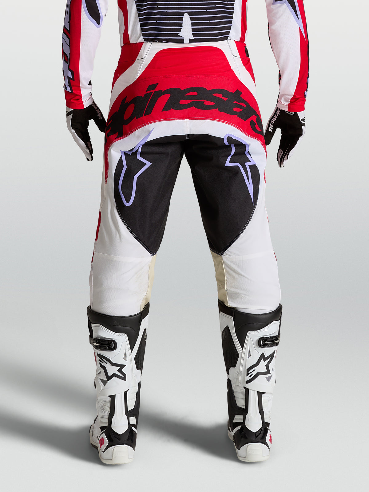 Alpinestars Techstar Maven Hose, Motocrosshose für den Rennsport, Rückansicht am Model, Rot, Weiß und Schwarz, verstärktes Gesäßpanel und athletische Rennpassform.