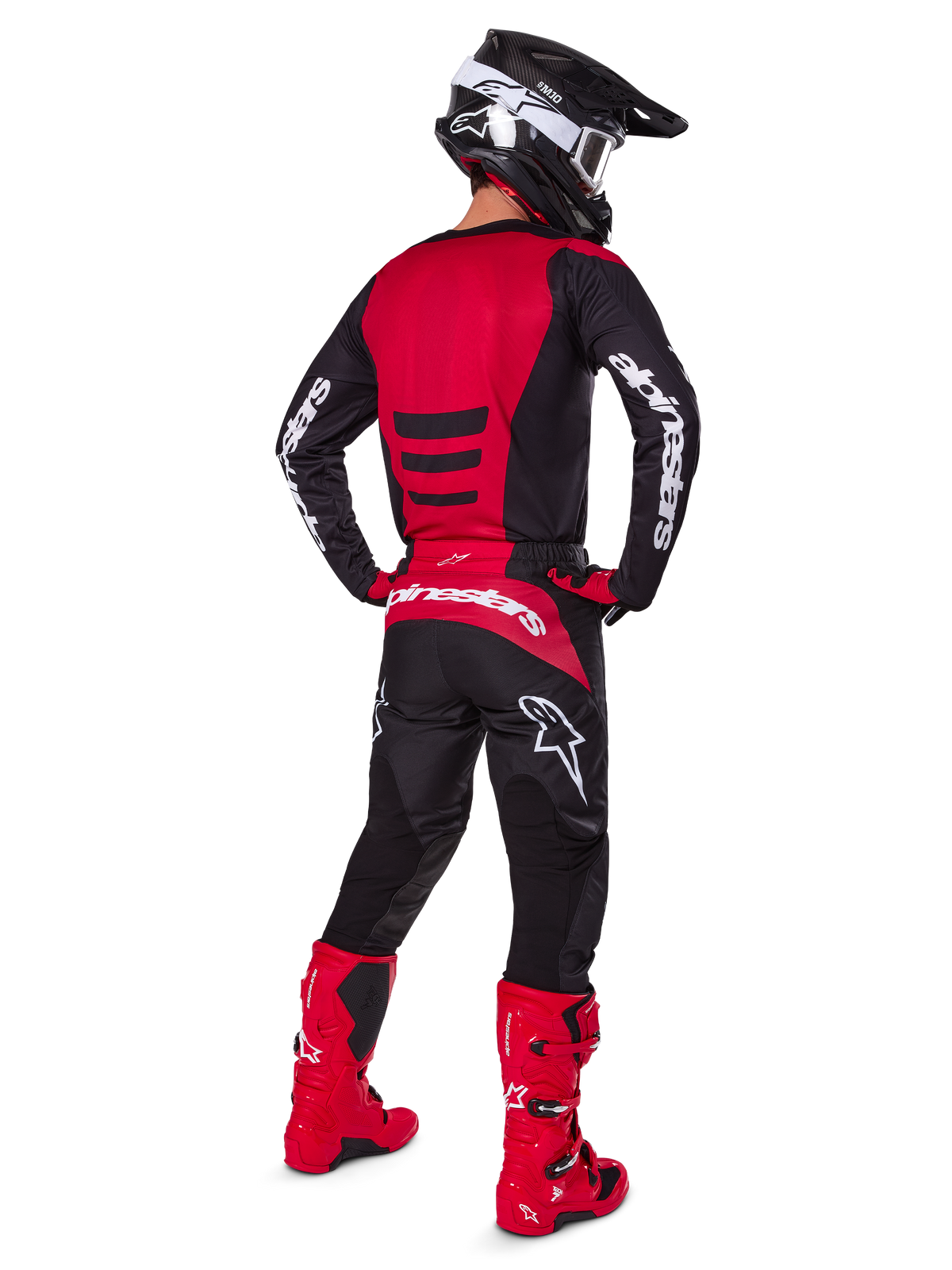 Motocross-Fahrer, der das Alpinestars 2025 Fluid Haul Gear Set in der Rückansicht trägt, rot-schwarzes Jersey mit weißem Branding, passende schwarze Hose mit roten Akzenten, leuchtend rote Stiefel und schwarzer Helm mit weißer Brille, komplett aufeinander abgestimmtes Outfit für Offroad-Rennen