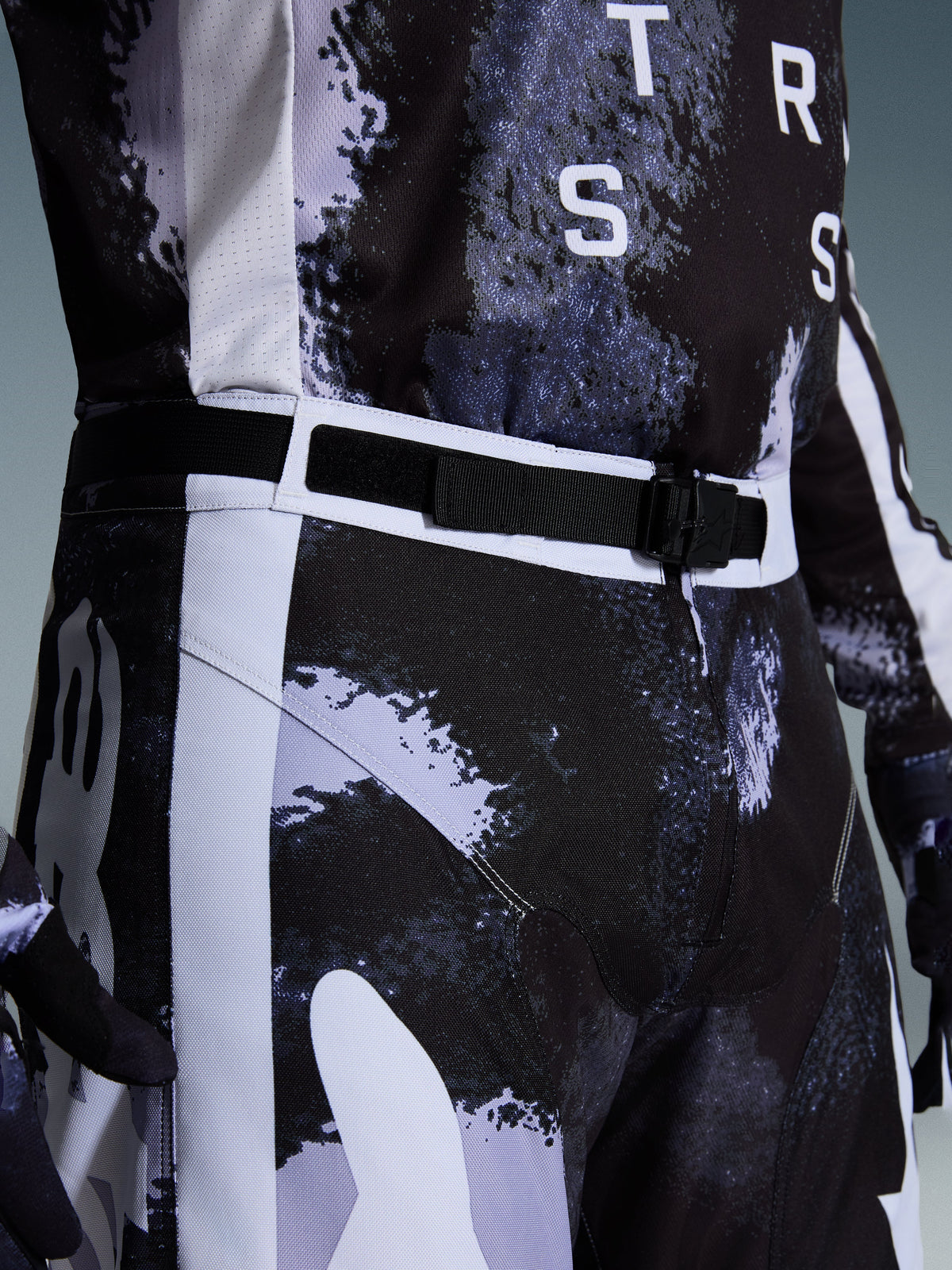Alpinestars 2026 Racer Lahnd Hose, Motocross-Hose in Iron Camo, Nahaufnahme des verstellbaren Taillengürtels und der SX2-Magnetschnalle, grau-schwarzes Camouflage-Muster, strapazierfähige 600D-Polygewebe-Konstruktion