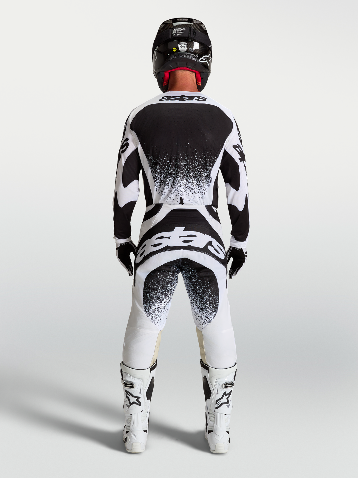 Alpinestars Techstar Swan Trikot und Hose, Herren-Motocross-Ausrüstung in Schwarz und Weiß, Rückansicht mit Branding.
