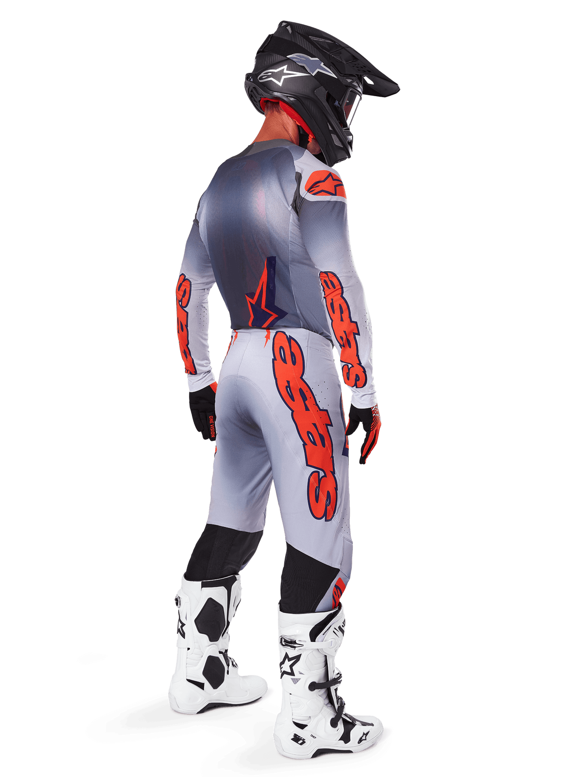 Motocross rider from the back wearing Alpinestars 2025 Supertech Lipan Pants in Gray and Orange Fluo, matching long-sleeve jersey, black helmet, and white and black tech boots, complete professional off-road racing gear.
