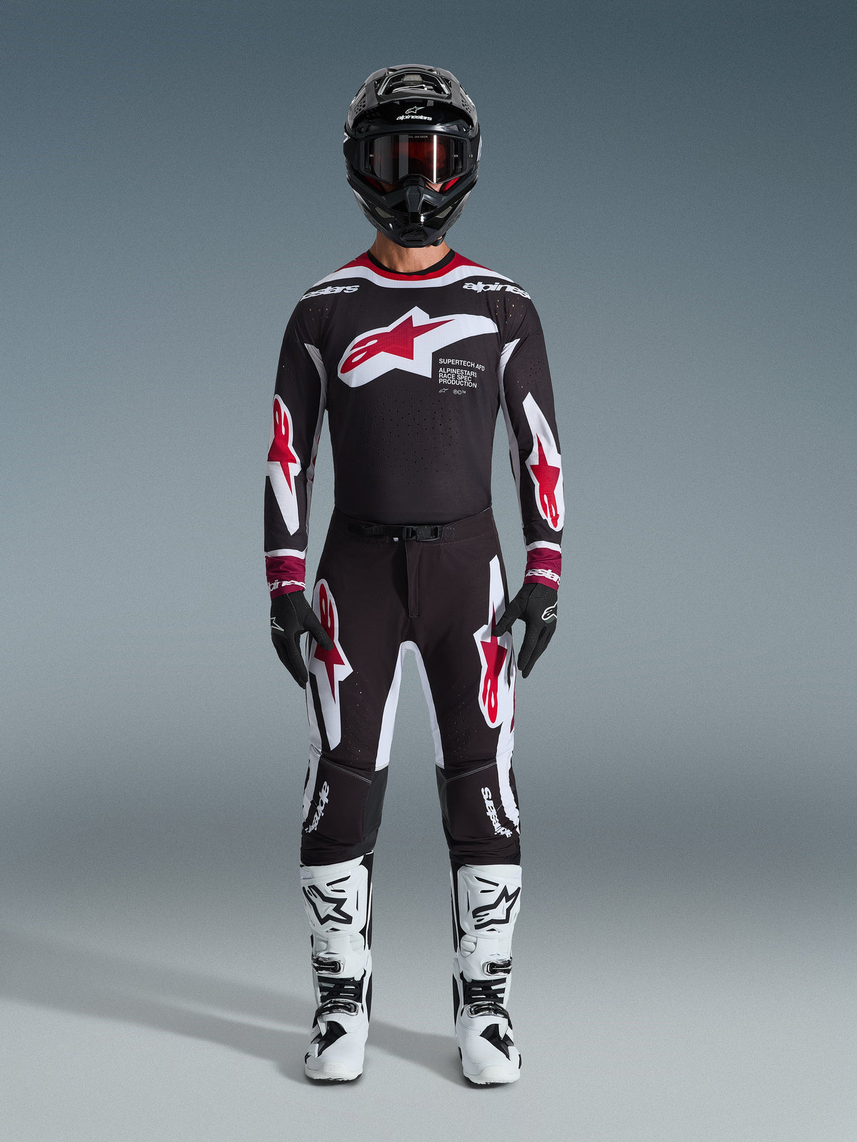 Alpinestars 2026 Supertech AFD Vista Gear Set, Motocross Racing Gear, Black with Red and White accents, full racing outfit including jersey and pants with star logo design, black helmet and white boots, professional MX apparel for off-road performance