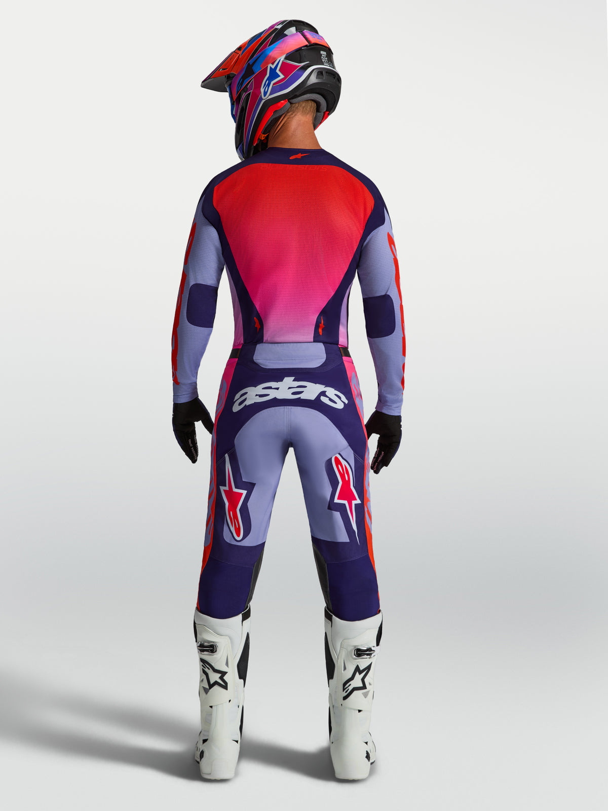 Alpinestars Racer Air Hunt Hose, lila und pinke Motocross-Hose am Model von hinten, belüftete Rennsporthose mit Astars-Logo.