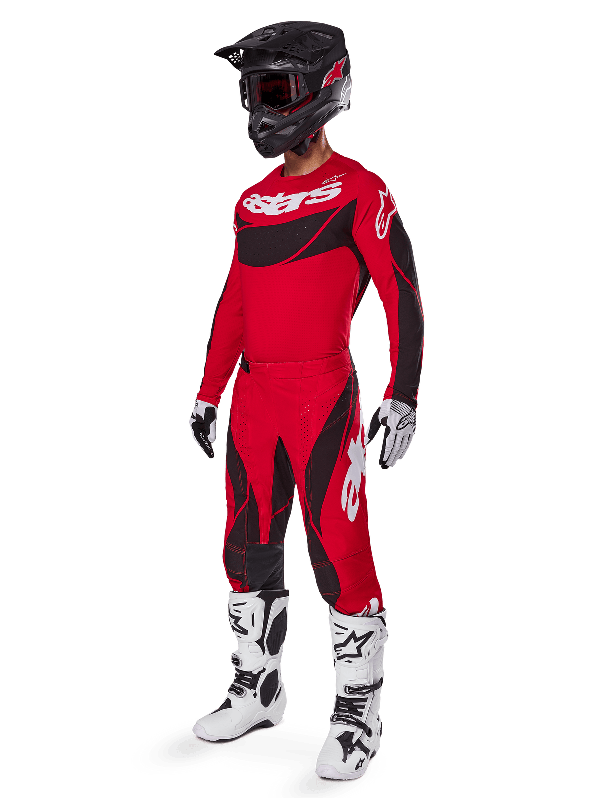 Motocross-Fahrer in kompletter Rennausrüstung mit Alpinestars 2025 Techstar Dreem Hose in Hellrot und Schwarz, passendes rot-schwarzes Trikot mit weißem Logo, schwarzer Helm und weiß-schwarze Stiefel, abgestimmtes Outfit für Offroad-Rennen
