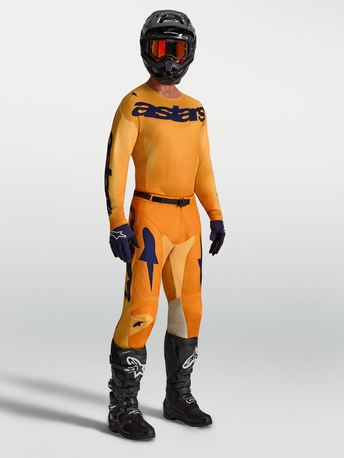 Alpinestars Racer Amber Hose und Trikot, Motocross-Rennausrüstung für Herren, Orange und Dunkelblau, kombiniert mit schwarzen Stiefeln und Helm