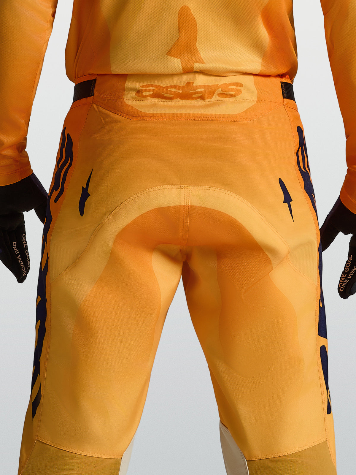 Alpinestars Racer Amber Herren-Motocrosshose in Orange und Dunkelblau mit verstärktem Gesäßbereich und Astars-Logo hinten.