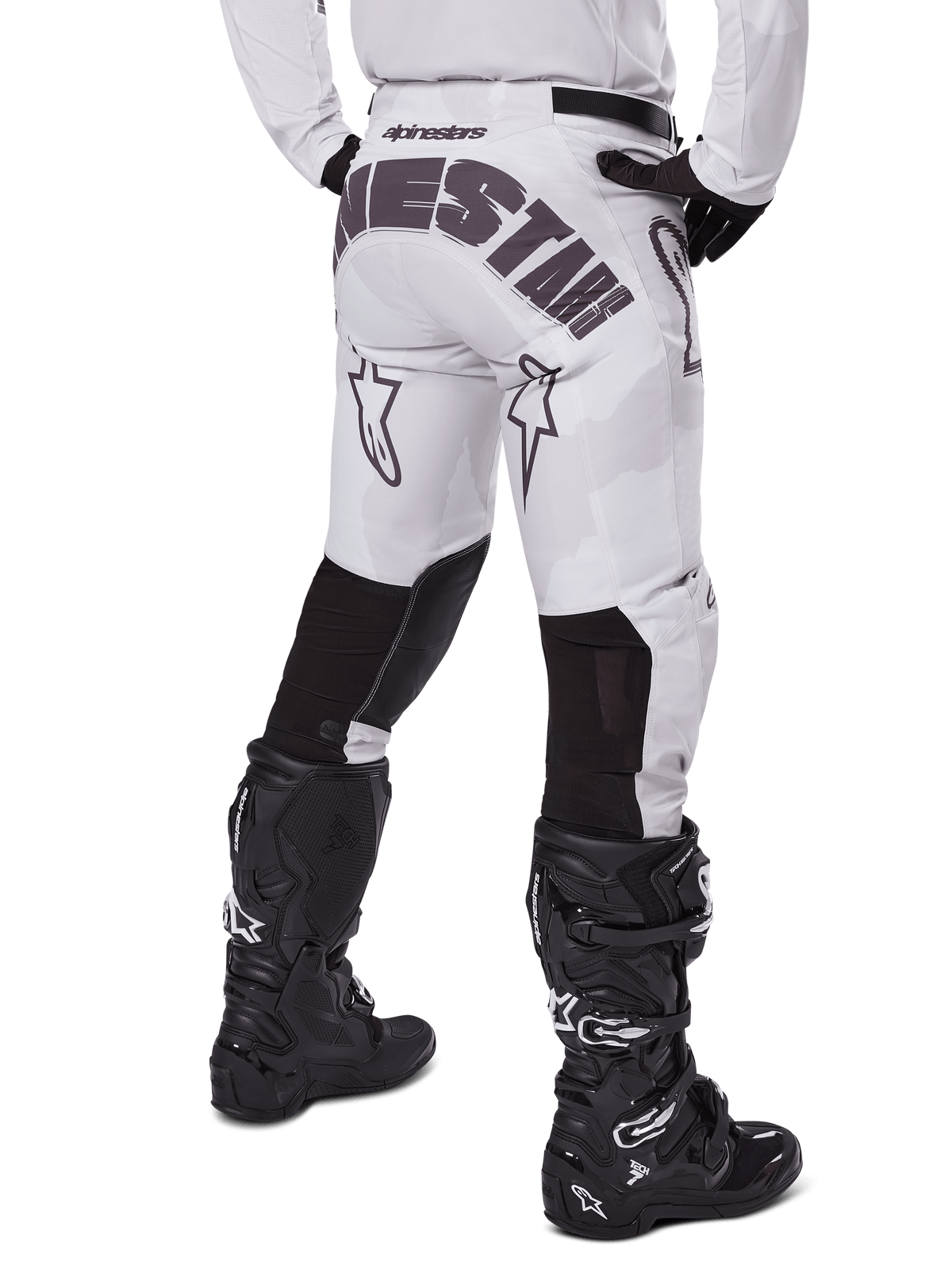 Alpinestars 2025 Racer Hollow Hose, Motocross-Hose, Light Camo Brown, Rückansicht des Fahrers mit großem Branding am Gesäß und schwarzen Stretch-Einsätzen an den Unterschenkeln, kombiniert mit schwarzen Tech 7 Stiefeln