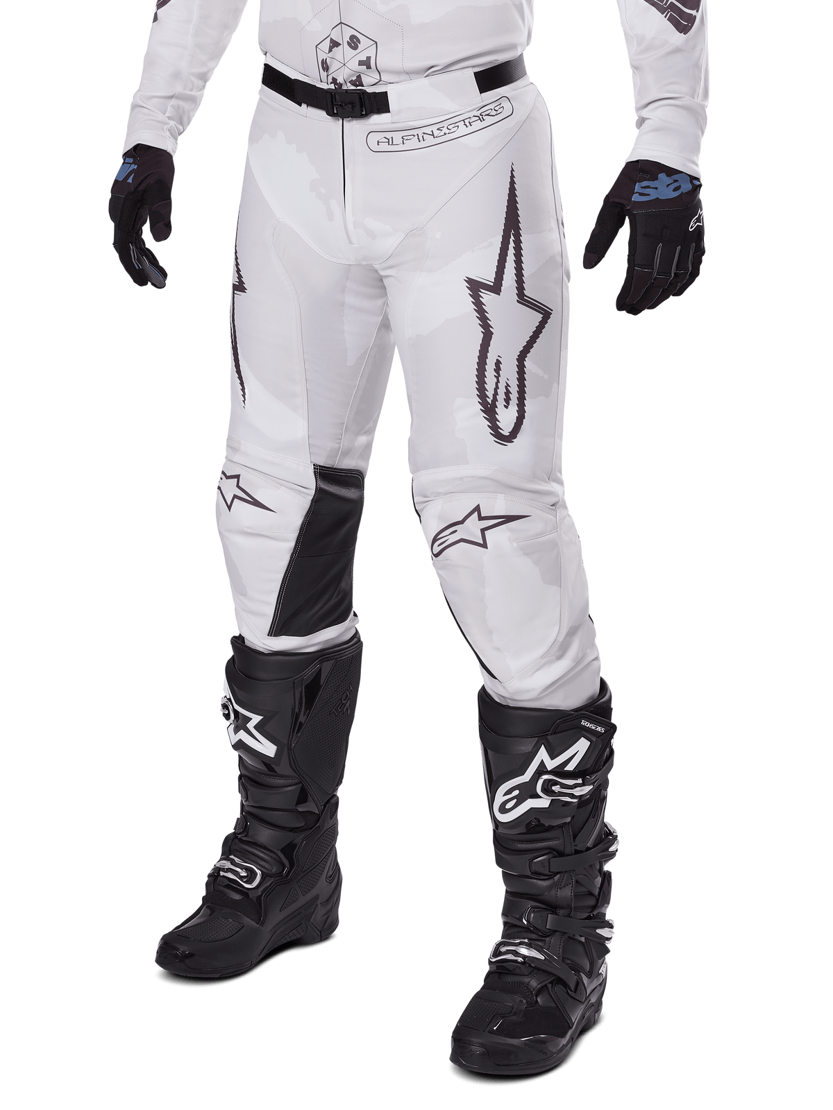 Alpinestars 2025 Racer Hollow Hose, Motocross-Hose, Weiß und Grau Camouflage, mit großen schwarz umrandeten Stern-Logos und schwarzen Leder-Innenknie-Einsätzen, kombiniert mit schwarzen Motocross-Stiefeln und Handschuhen, strapazierfähiges Design für Offroad-Rennsport
