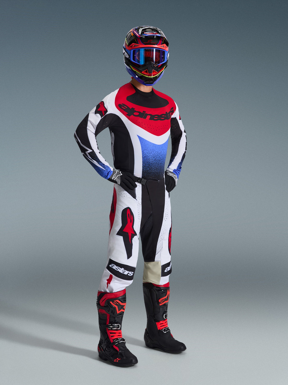 Alpinestars 2026 Techstar Knif Pants, Motocross Pants, Black White and Red, worn by a rider in full racing gear with matching jersey and boots, featuring bold red Alpinestars logos on white panels and a performance-oriented athletic fit.