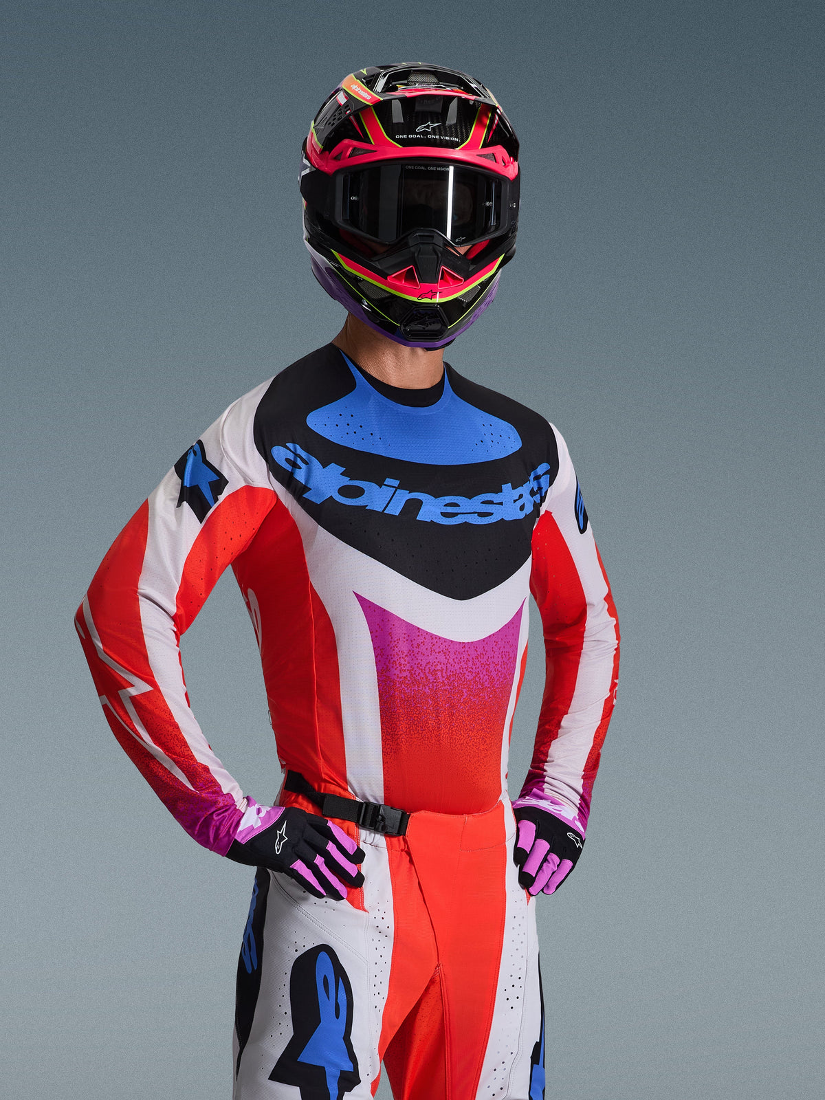 Alpinestars 2026 Techstar Knif Gear Set, Motocross-Rennausrüstung, weiß-rotes Jersey mit pinkfarbenem Farbverlauf und blauen Akzenten, passende weiß-rote Hose, pink-schwarzer Helm mit dunkler Brille, schwarz-pinke Handschuhe, koordiniertes Outfit für Offroad-Performance