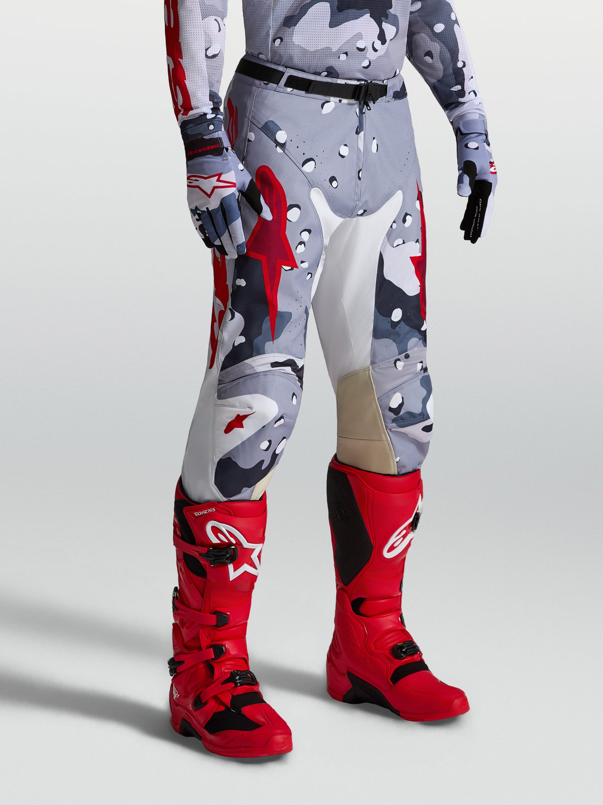 Alpinestars Racer Air Lone Motocross-Hose, Grau-Camo und Rot, perforiertes Design für Offroad-Fahrten, am Model gezeigt.