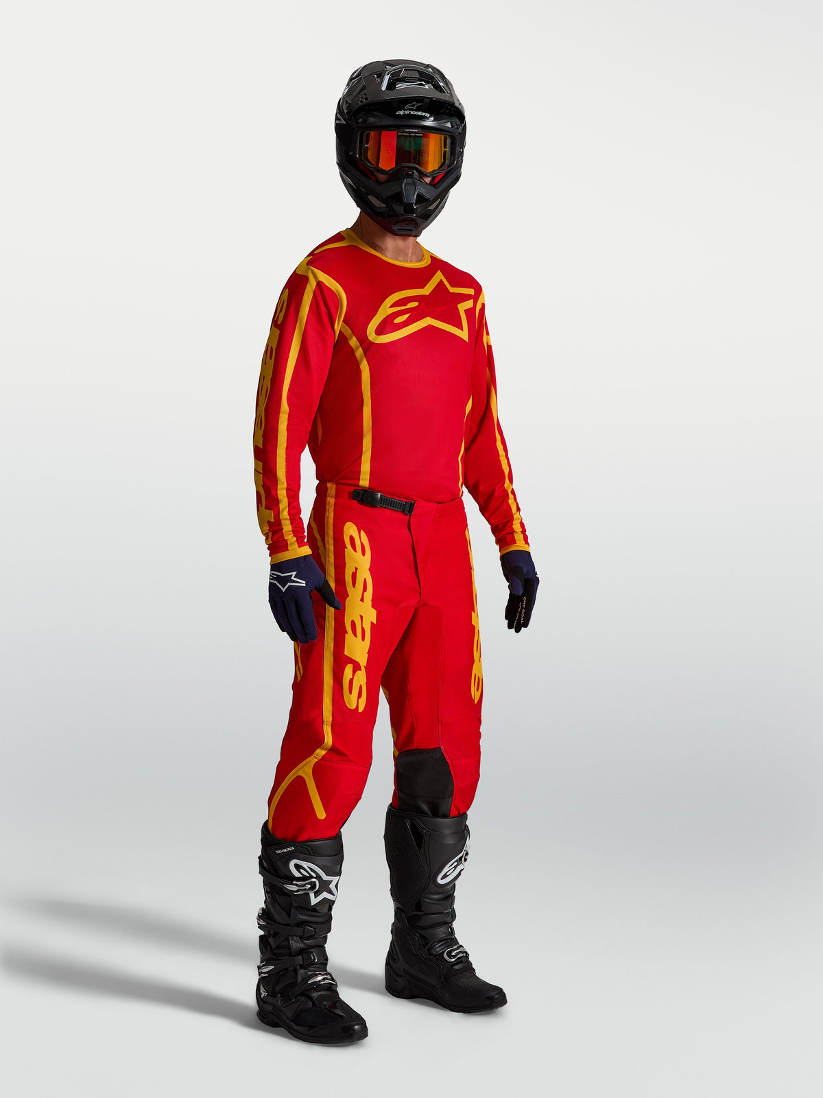 Alpinestars Fluid Apex V2 Hose, Motocross-Hose für Herren, Rot und Gold, strapazierfähiges 600D-Polygewebe, sportliche Passform, am Modell getragen mit passendem Trikot und Stiefeln für Offroad-Einsätze