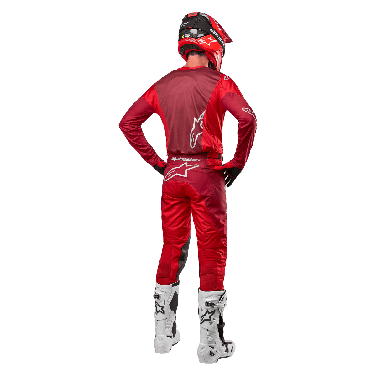 Alpinestars 2024 Racer Hoen Hose und passendes Trikot in Mars Red Burgundy, Rückansicht eines Motocross-Fahrers in kompletter Ausrüstung, roter Helm und weiße Stiefel, sportliche Passform und Branding für den Offroad-Rennsport