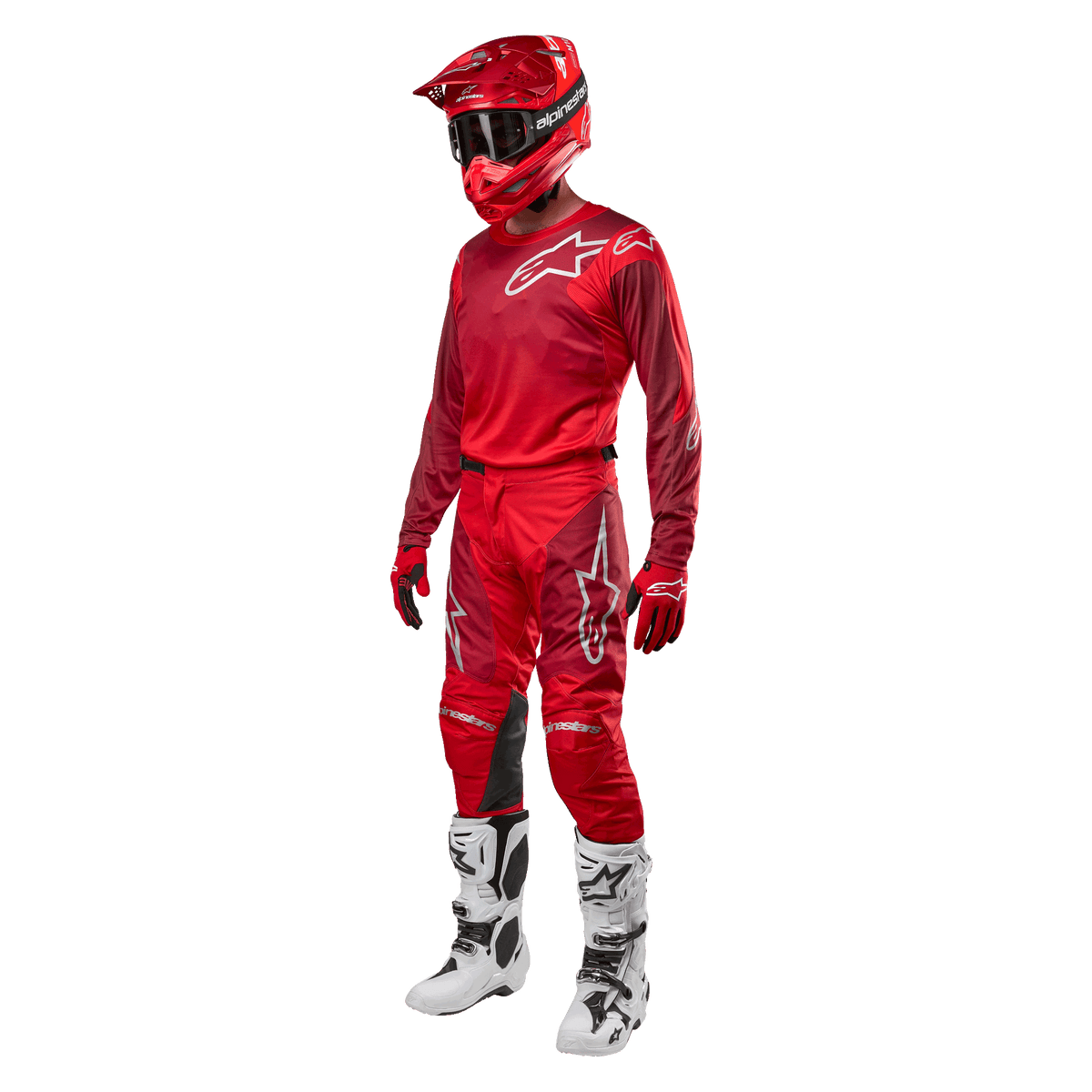 Motocross-Fahrer in kompletter Rennausrüstung, Alpinestars 2024 Racer Hoen Hose und Trikot in Mars Red Burgundy, roter Helm, rote Handschuhe und weiß-schwarze Stiefel, abgestimmtes Outfit für Offroad-Rennen