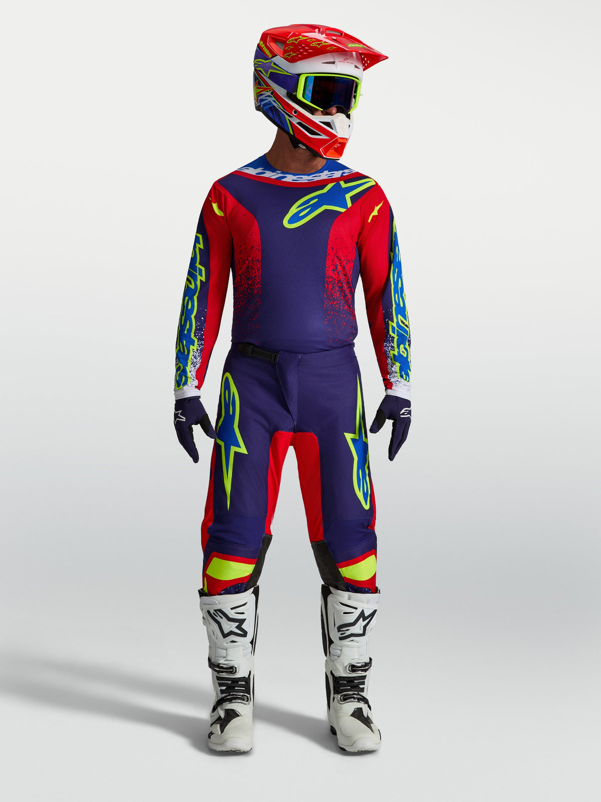 Alpinestars Fluid Drag Hose und 2027 Fluid Drag Gear Set, Herren-Motocross-Outfit in Blau und Rot mit weißen Stiefeln.
