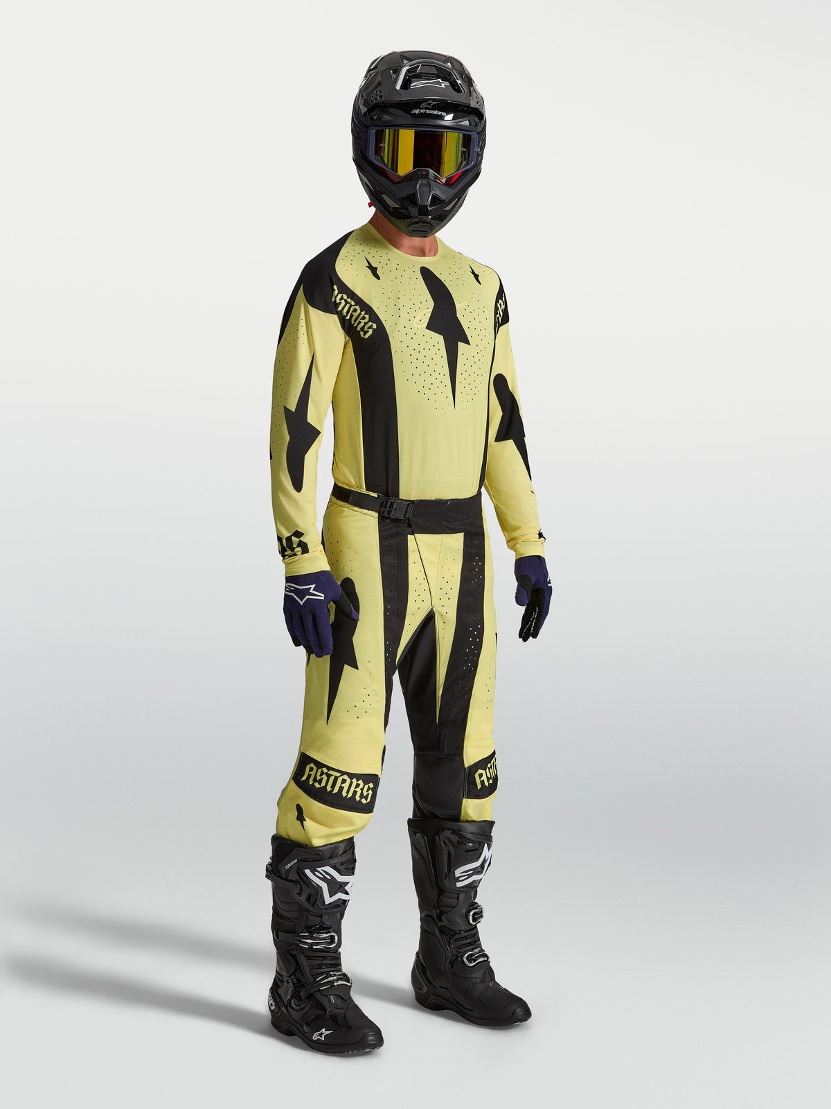Alpinestars Techstar Atrox Hose und Techstar Atrox Gear Set, Motocross-Rennkit für Herren, Gelb und Schwarz, robuste Stretch-Konstruktion, am Model mit Helm und Stiefeln.