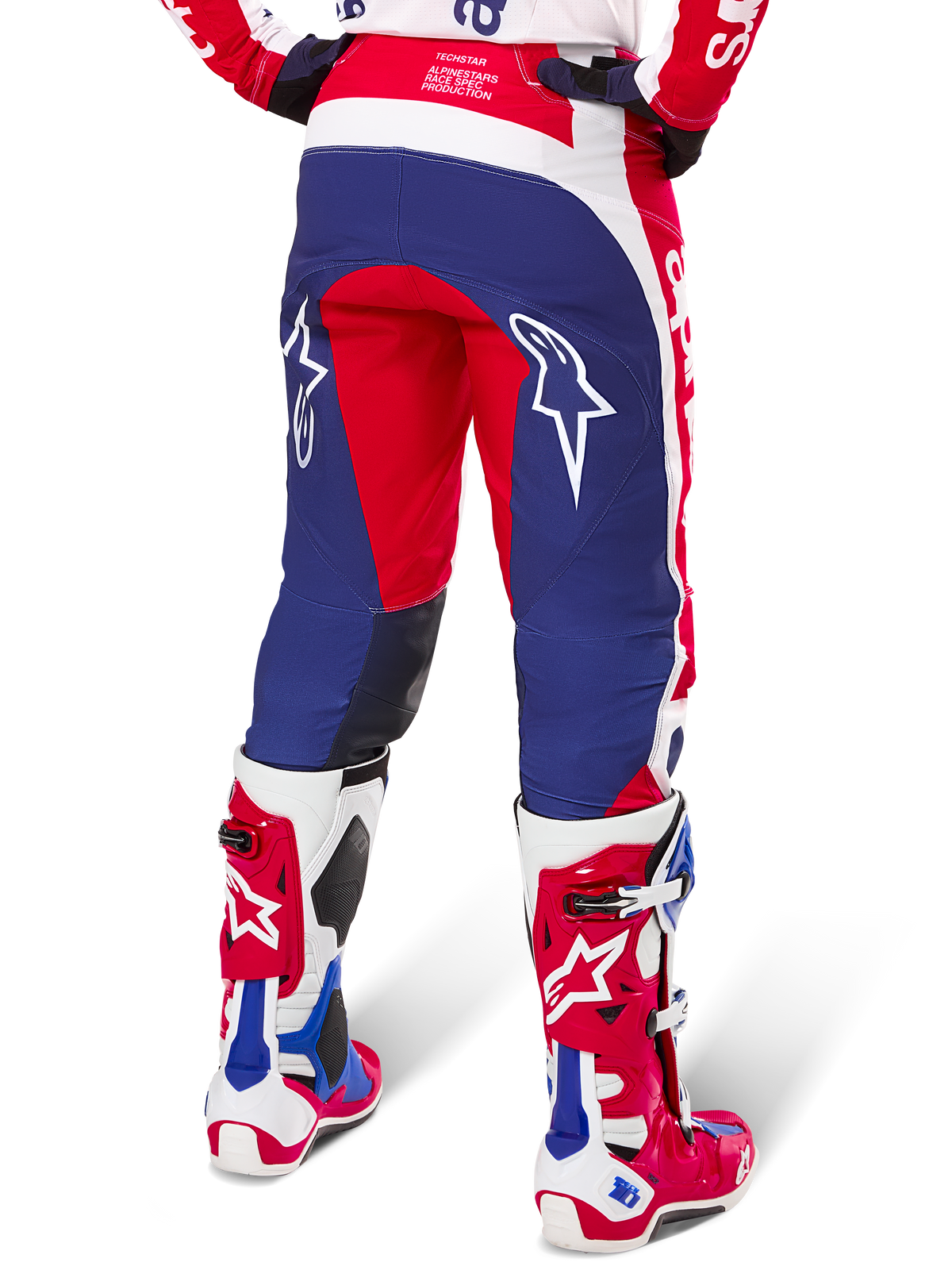 Alpinestars Limited Edition Techstar Fortitude Hose, Motocross-Hose, Rot, Weiß und Blau, Rückansicht getragen mit passenden rot-weißen Stiefeln, weiße Stern-Logos auf den Oberschenkeln, strapazierfähiges Multi-Panel-Design für professionellen Offroad-Rennsport