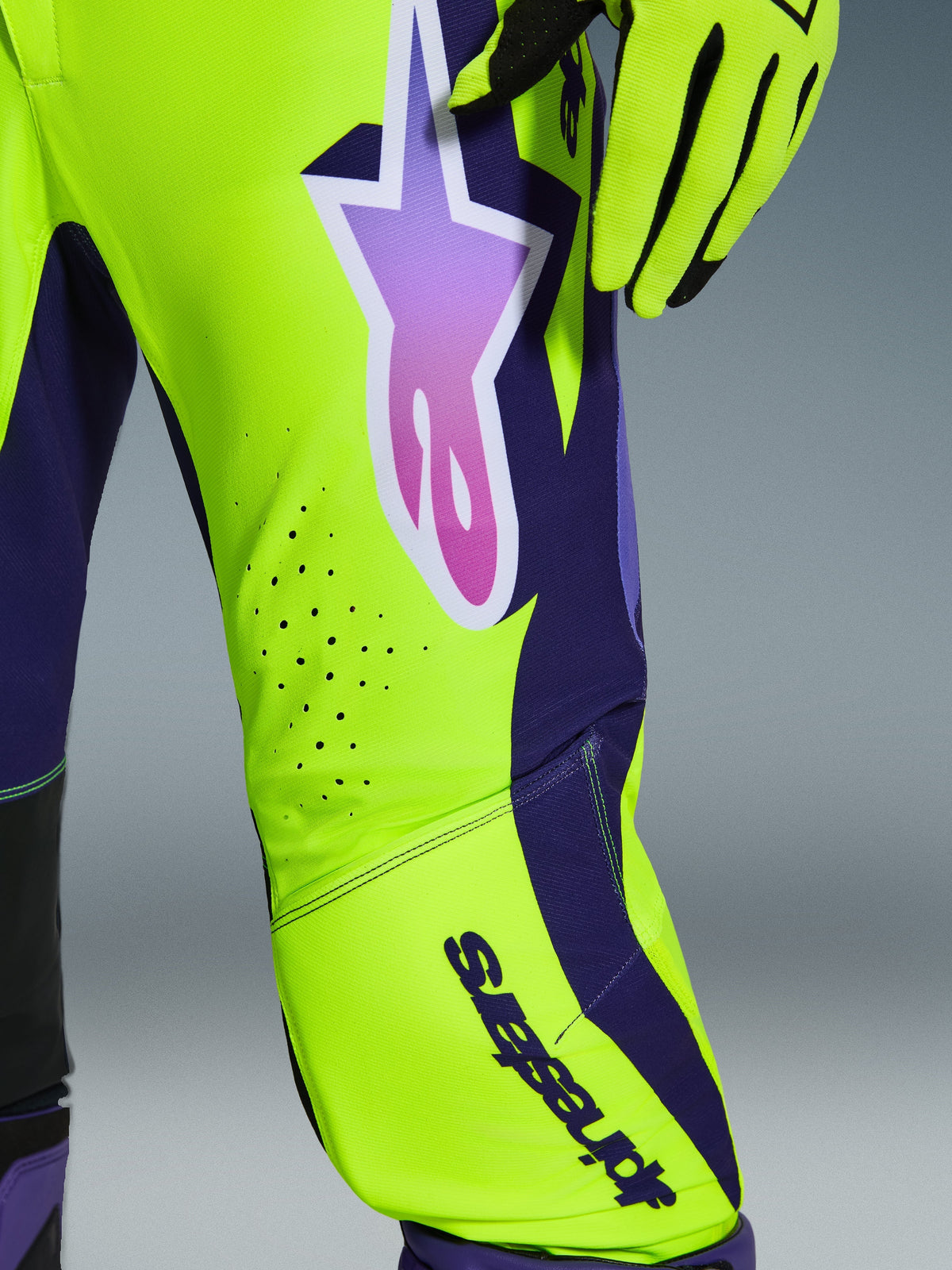 Alpinestars 2026 Supertech Vista Pants, Motocross Pants, Yellow Purple Black, close-up view of the leg showing neon yellow and dark purple panels, large gradient purple star logo, laser-cut ventilation perforations, professional racing apparel
