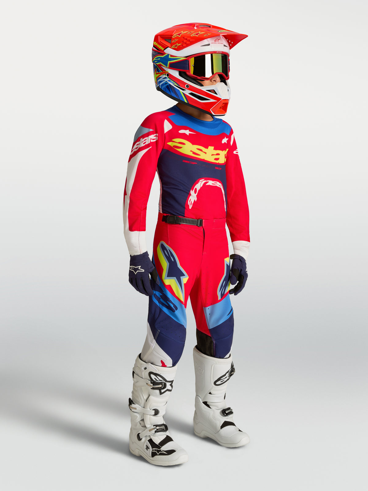 Alpinestars Youth Supertech Dyna Pants, Red and Navy Blue Motocross Gear, on-model with matching jersey, helmet, and boots.