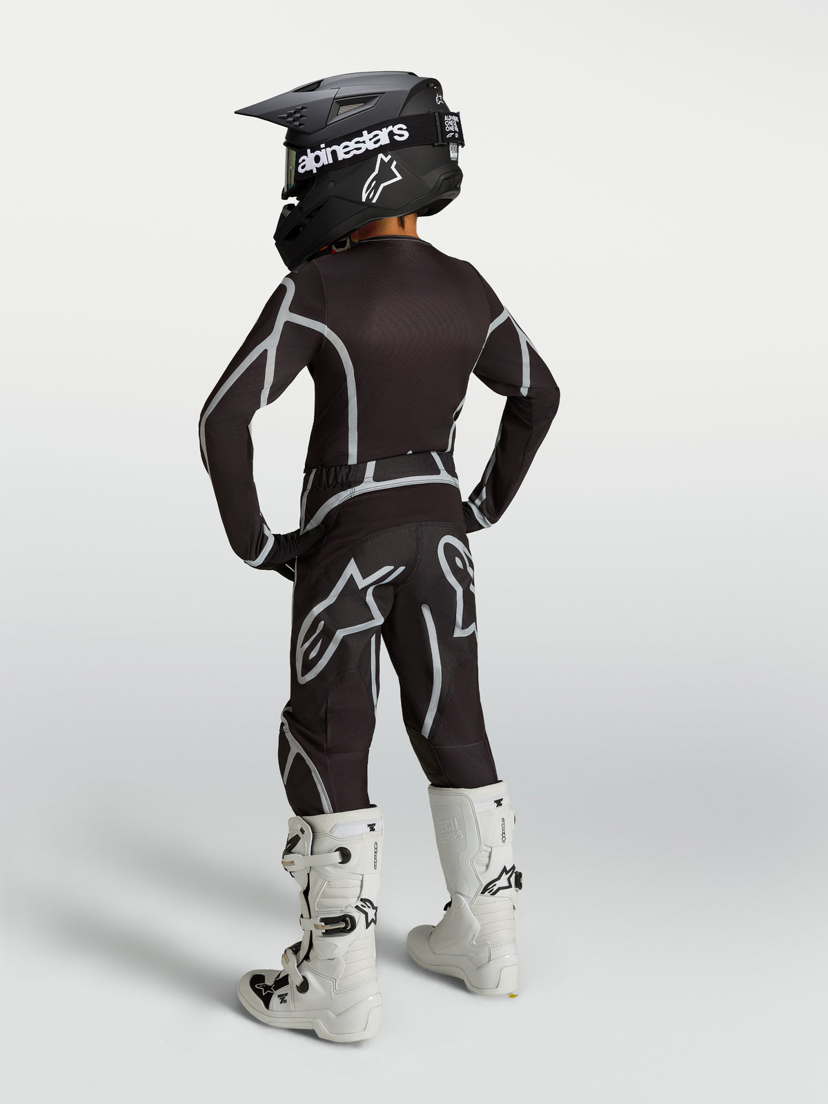 Alpinestars Jugend Fluid Apex V2 Hose, leistungsstarke Motocross-Hose für Kinder, Schwarz und Silber, Rückansicht als Teil einer kompletten MX-Rennausrüstung.