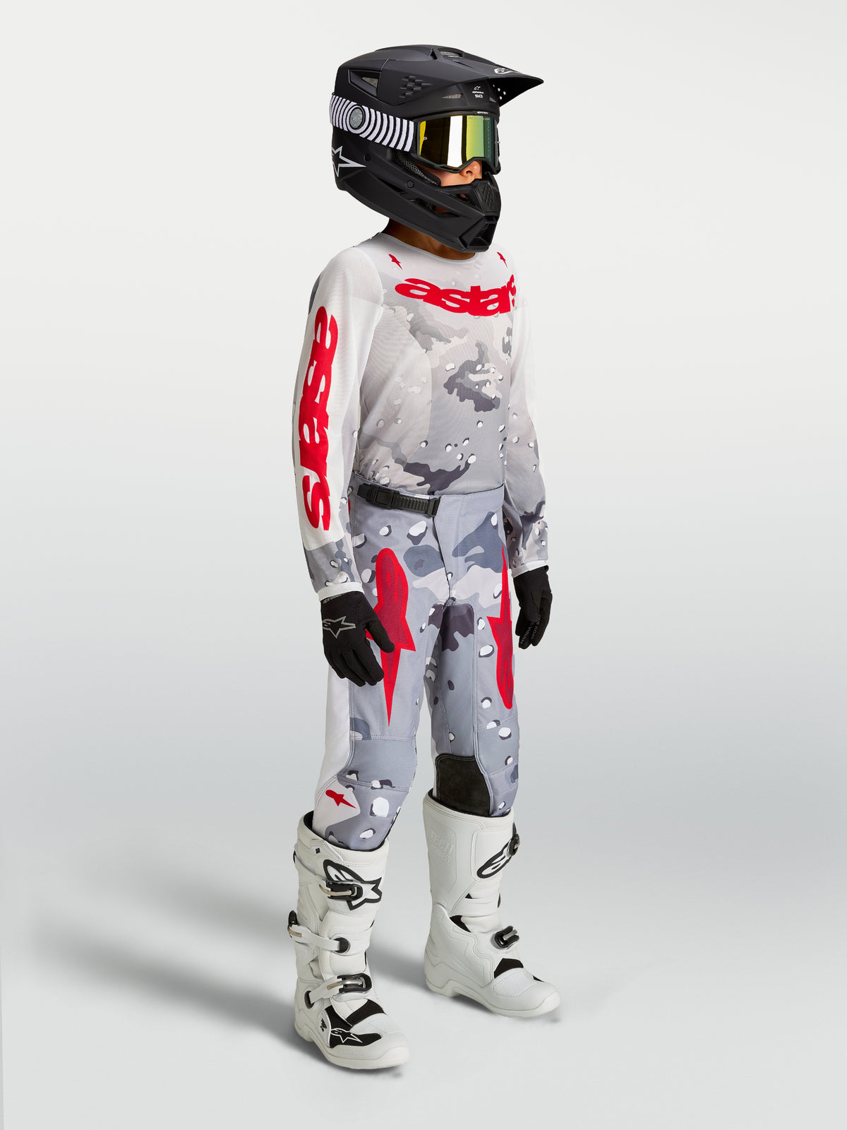 Alpinestars Fluid Jugend-Hose Lone 2027, MX-Hose, Grau und Rot mit Camouflage, 600D-Gewebe, mit weißen MX-Stiefeln.