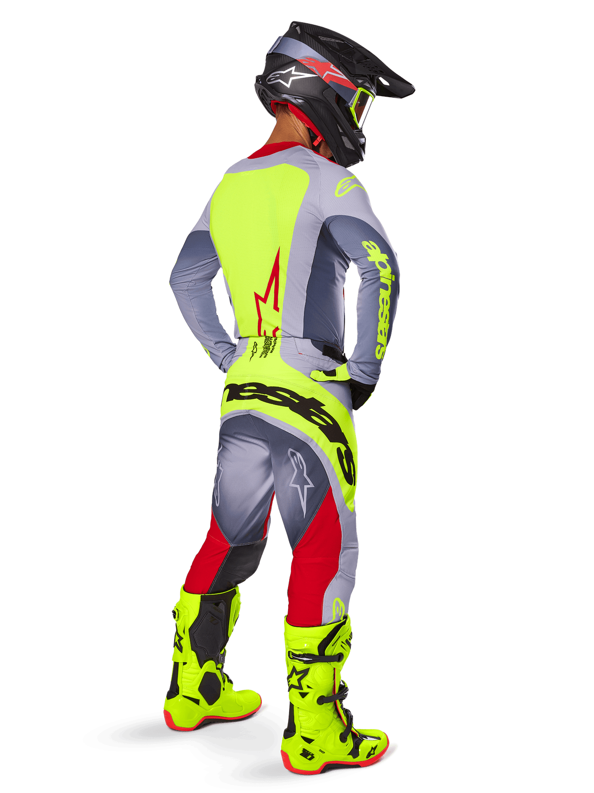 Motocross rider from behind wearing the Alpinestars 2025 Techstar Melt Jersey in Bright Red Gray, featuring a bright yellow back panel and gray sleeves, matching gray and red pants with yellow branding, bright yellow motocross boots, and a black helmet with yellow goggles, coordinated off-road racing kit