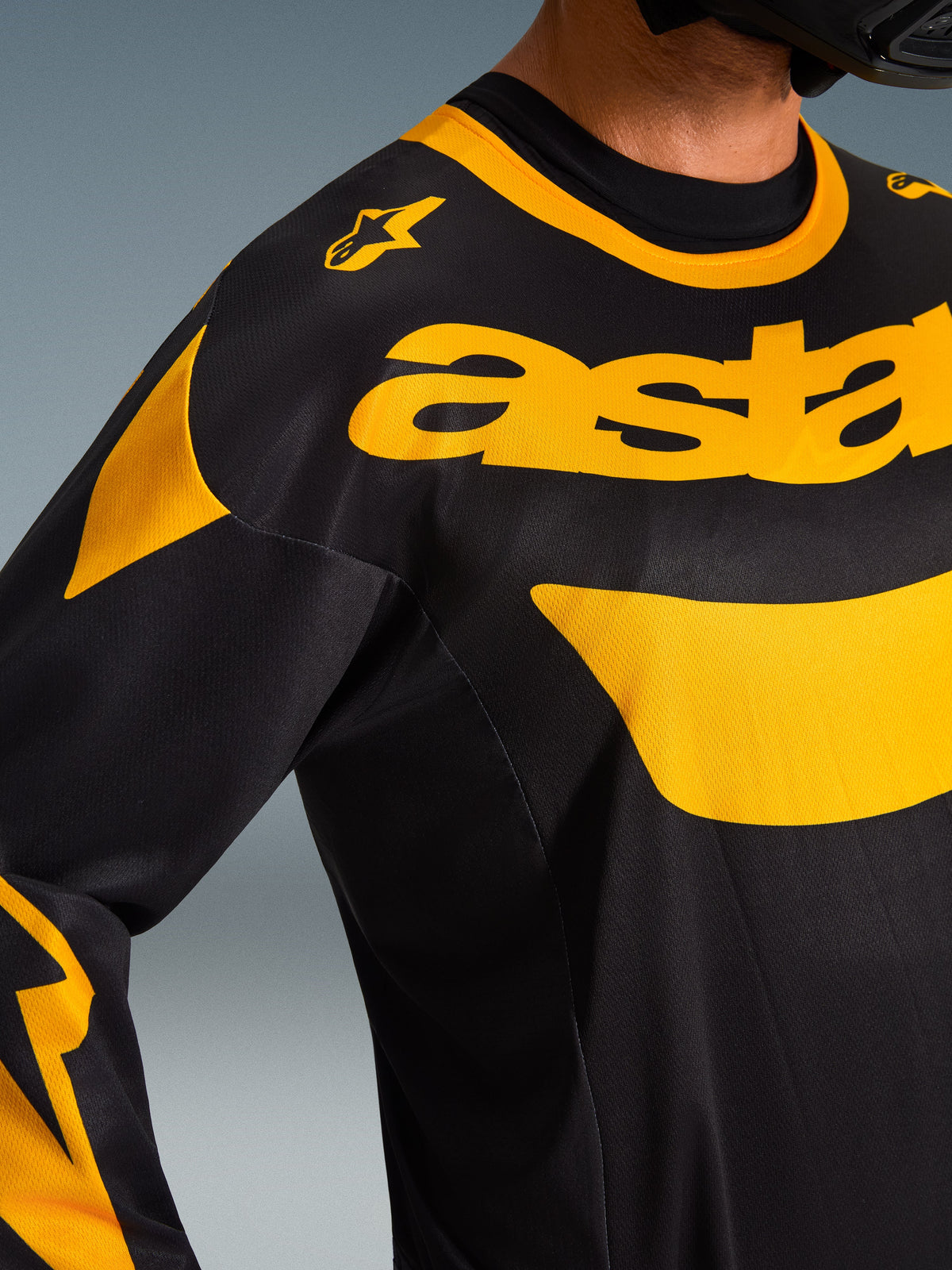 Alpinestars 2026 Racer Riway Jersey, Nahaufnahme, Schwarz und Gelb mit markantem gelbem Branding auf der Brust, technisches Mesh-Gewebe zur Belüftung, Performance-Motocross-Bekleidung