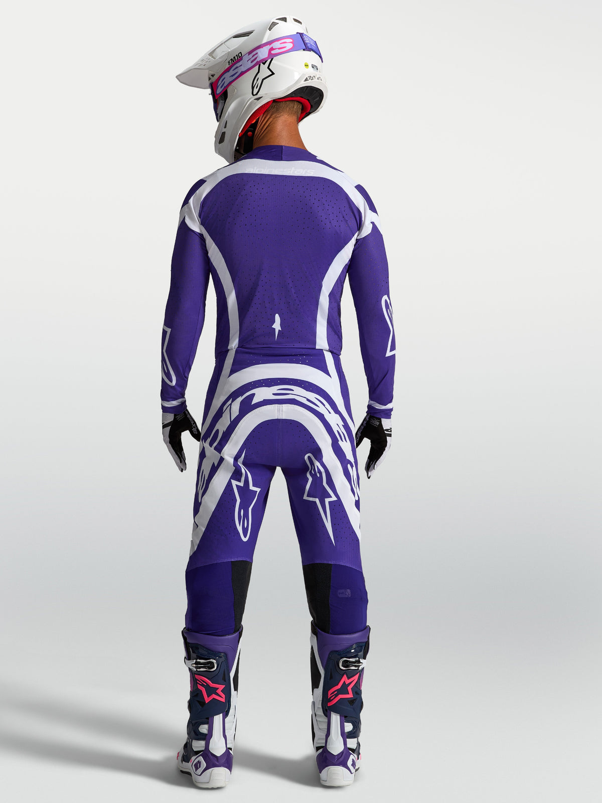 Alpinestars Supertech Vesta Trikot und Motocross-Kombi, Herren-Offroad-Outfit in Dunkelblau und Weiß, Rückansicht mit Helm und Stiefeln, athletische Rennpassform.