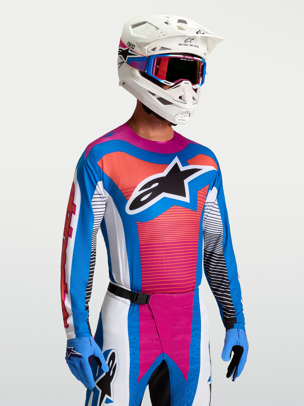 Alpinestars Techstar Maven Trikot, Herren-Motocross-Trikot in Blau und Hot Coral, athletische Passform, getragen mit MX-Helm.