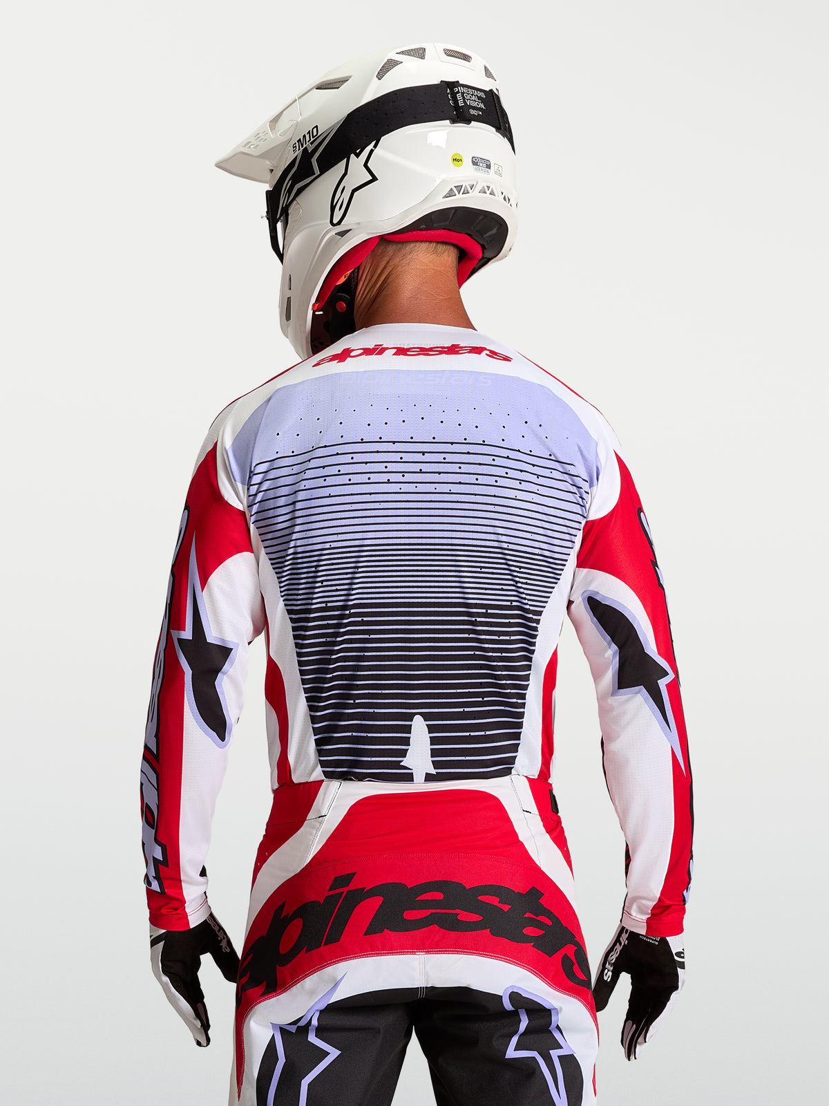 Alpinestars Techstar Maven Trikot, Motocross-Renntrikot, Rot und Weiß, atmungsaktives Gewebe, Rückansicht am Fahrer.