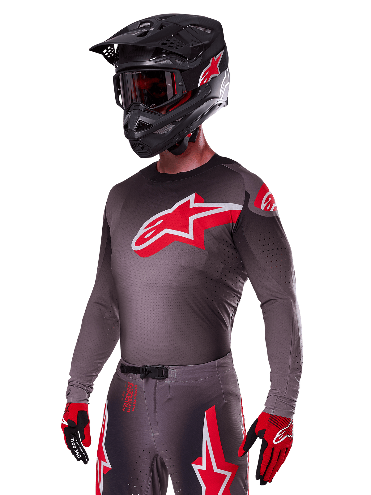 Alpinestars 2025 Supertech Lipan Ausrüstungsset, Motocross-Fahrer in dunkelgrauem Jersey und Hose mit roten und weißen Akzenten, großes rotes Alpinestars-Logo auf der Brust, lasergeschnittene Perforationen zur Belüftung, schwarzer Helm, rote Brille und rot-schwarze Handschuhe