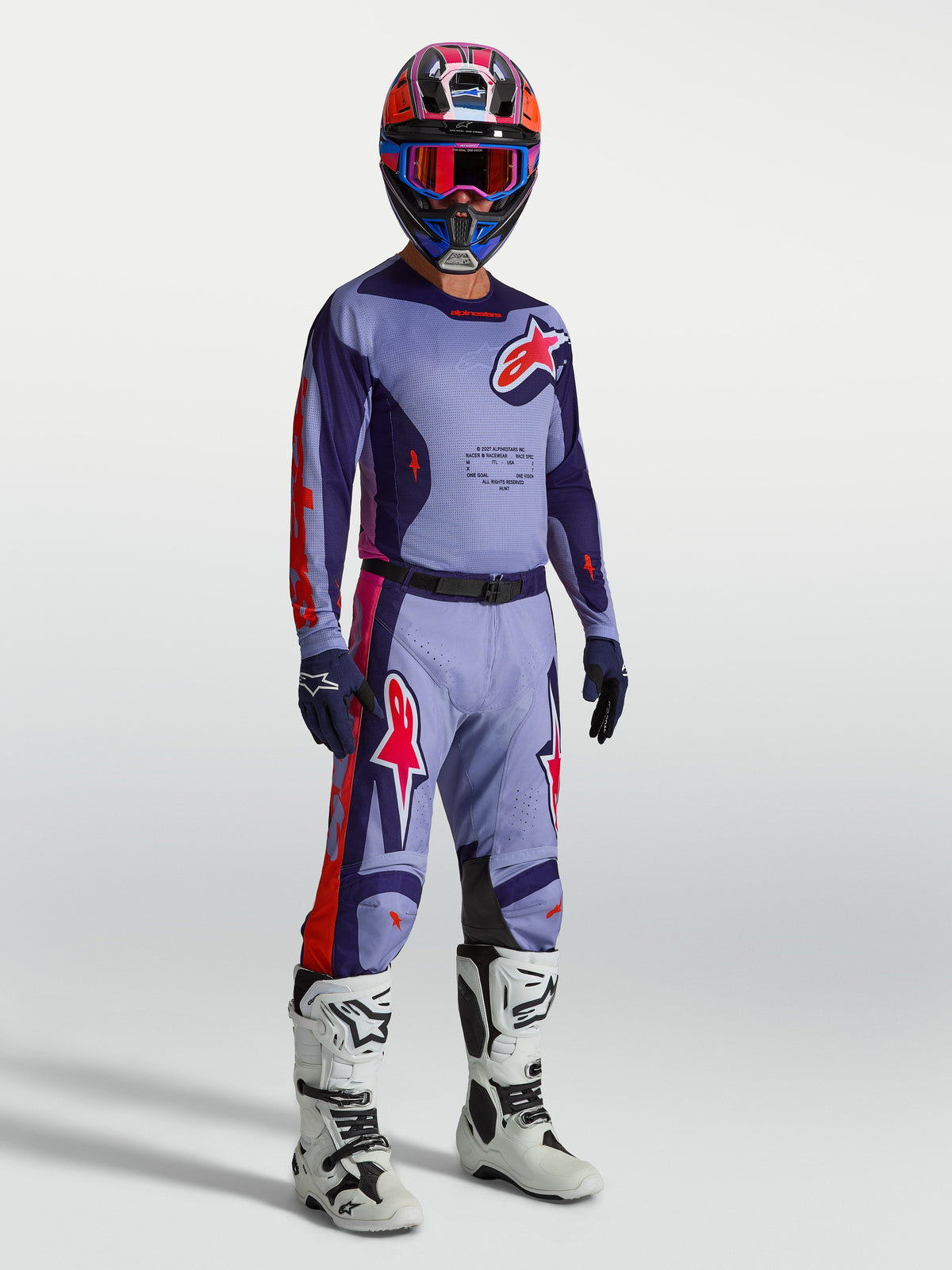 Alpinestars Racer Air Hunt Ausrüstungsset, lila und rote Motocross-Ausrüstung mit belüftetem Trikot, Hose und weißen Motocross-Stiefeln.