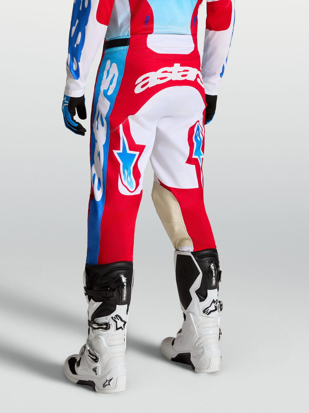 Alpinestars Racer Hose Hunt, Rot und Weiß, Motocross-Hose an Model mit Sternen-Grafiken, Ziegenleder-Knieeinsätzen und ergonomischem Sport-Schnitt.