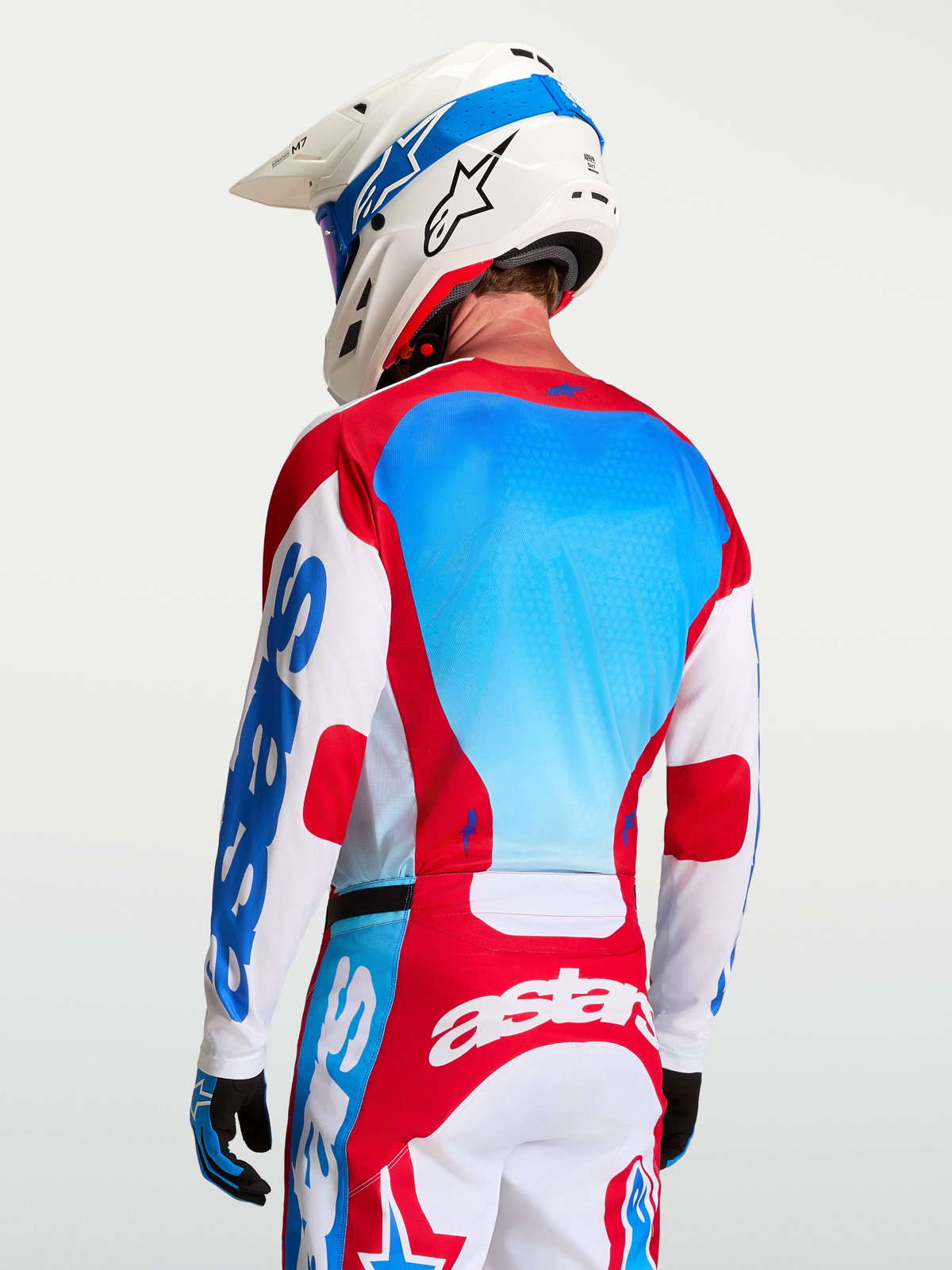 Alpinestars Racer Hunt Motocross Jersey in White, Red, and Blue, showing back mesh panels and race fit on a model.