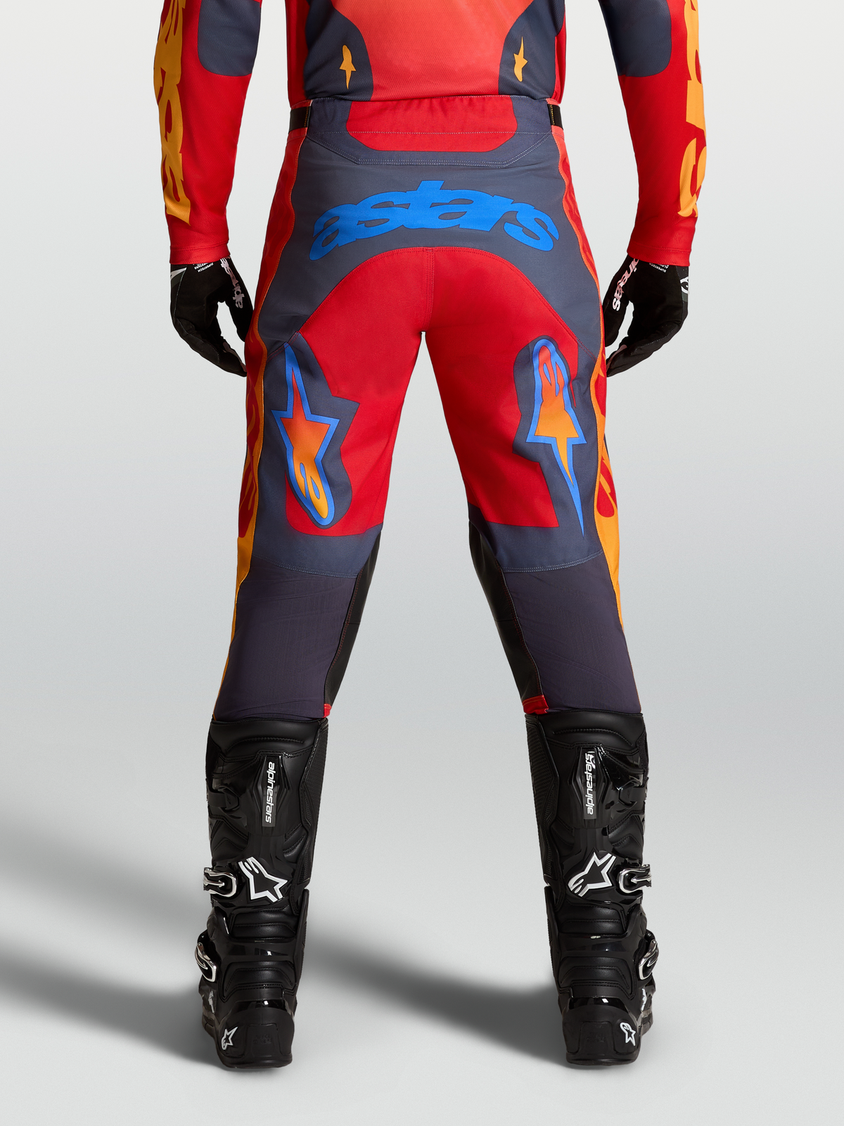 Alpinestars Racer Hunt Hose in Rot und Grau, Herren-Motocrosshose mit blauem Astars Logo am Gesäß und vorgeformter Beinstruktur.